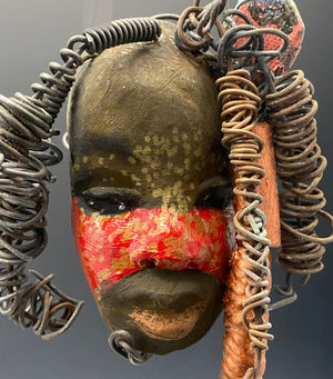 I started making art soon after seeing authentic African artwork at the Smithsonian Museum of African Art. I was in total awe. Gaby was inspired by my visit there.   Gaby has a  two tone complexion of earthy browns and bright red.. She is 5" x 4" and weighs 7.4 ozs. Gaby has 3 handmade raku fired beads. She has over 5 feet of coiled 16 gauge wire hair. Got Questions????