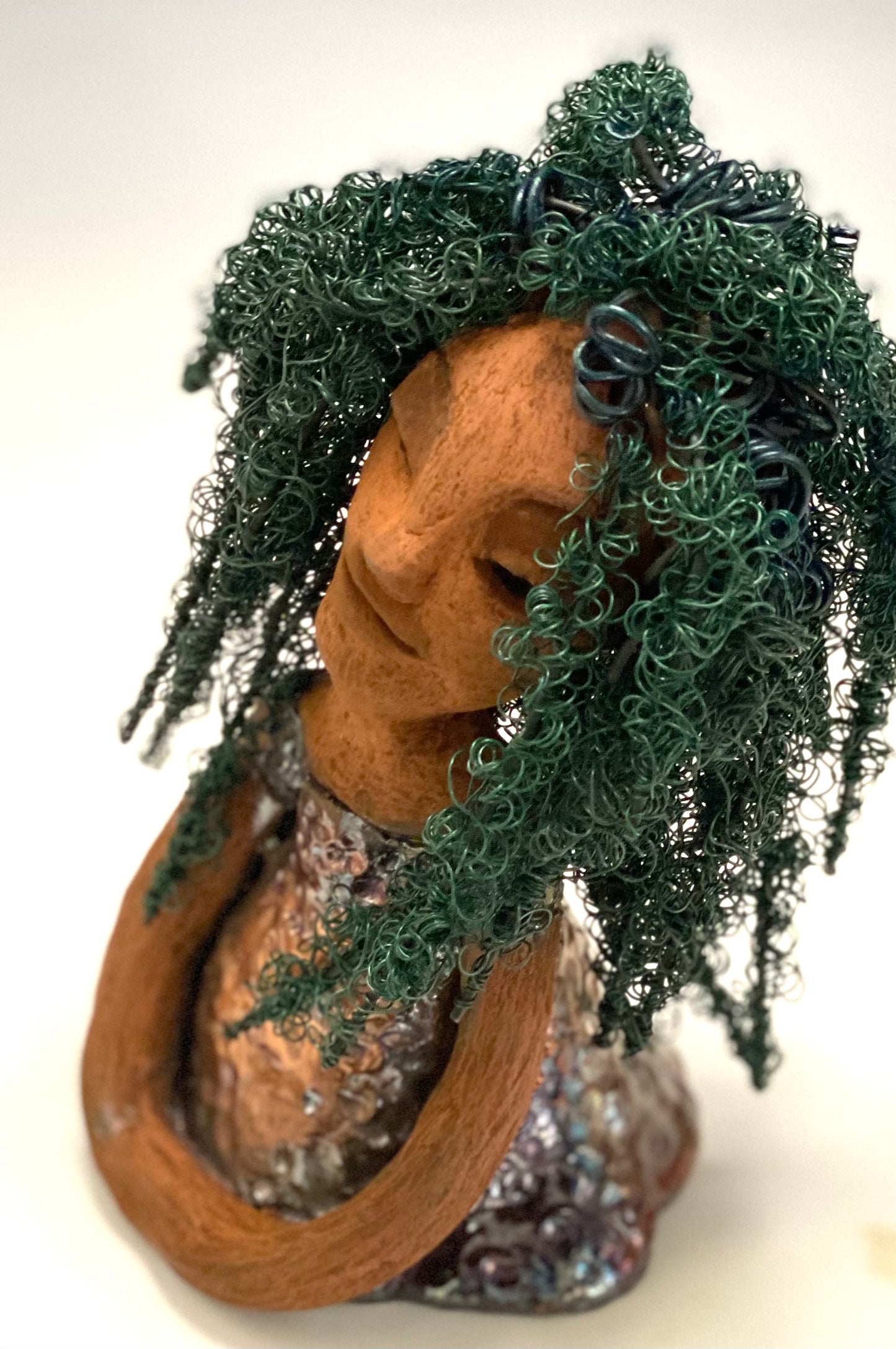 Nia Nia stands 8" x 5" x 5.5" and weighs 1.04 lbs. She has a lovely honey brown complexion with soft brown lips. She has long twisted wire locs hairstyle waist down!  Nia has a glossy metallic copper glazed dress. She has over 75 feet of 16 and 24 gauge emerald green wire for hair. It really took over 6 hours just to twist and do her hair! With  eyes wide opened, Alexis has hope of finding a new home.   