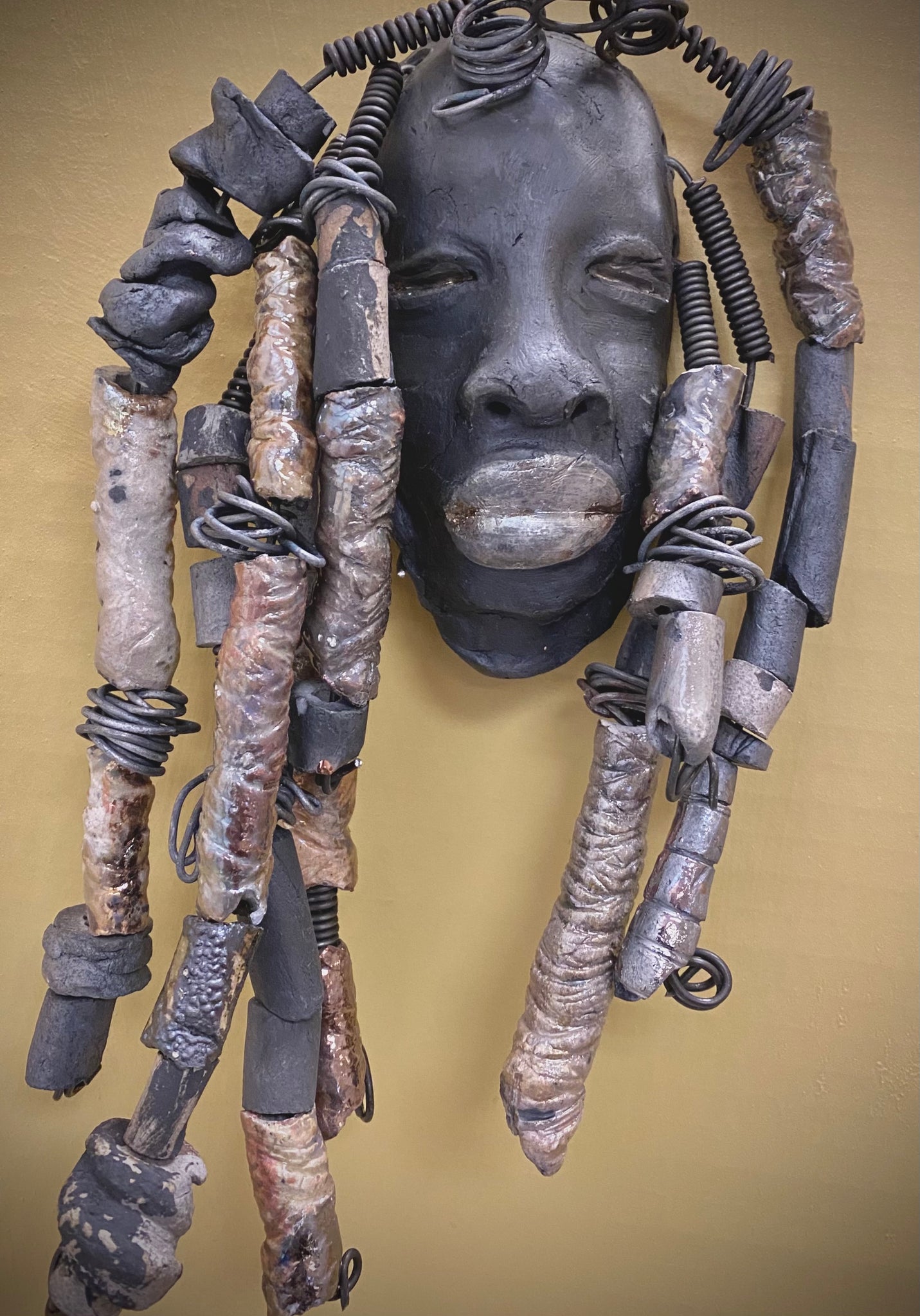 Meet Derrick! You Like Wise men; You gotta Love Derrick! I started making art soon after seeing authentic African artwork at the Smithsonian Museum of African Art. I was in total awe. Derrick was inspired by my visit there.   Derrick is a wise and distinguished gentleman who has a smoky dark complexion. He is approximately 5" x 11" and weighs 15 ozs. Derrick has an aged hairstyle of more than 20 handmade textured clay dreadlocks along with twist of coiled 16 gauge wire.