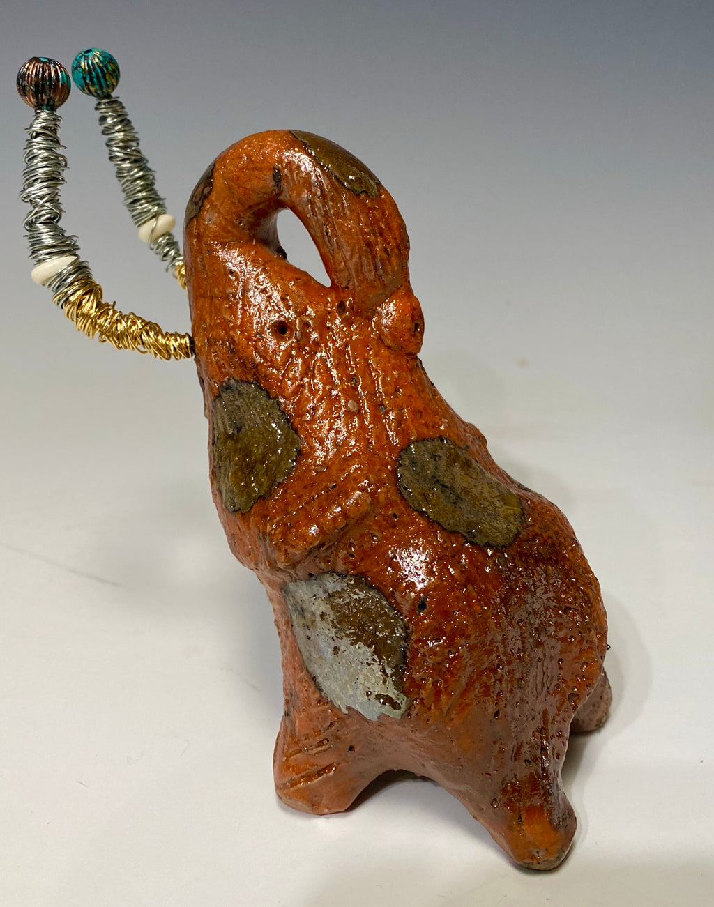 Raku Elephant Have you HERD!!!!!!  Just one of these lovely Raku Fired Elephant will make an excellent gift for your  friend, sorority or for your home’ special place centerpiece.  7" x 4" x 3" 11 ozs. Beautiful metallic gold and orange raku elephant For decorative purposely only.