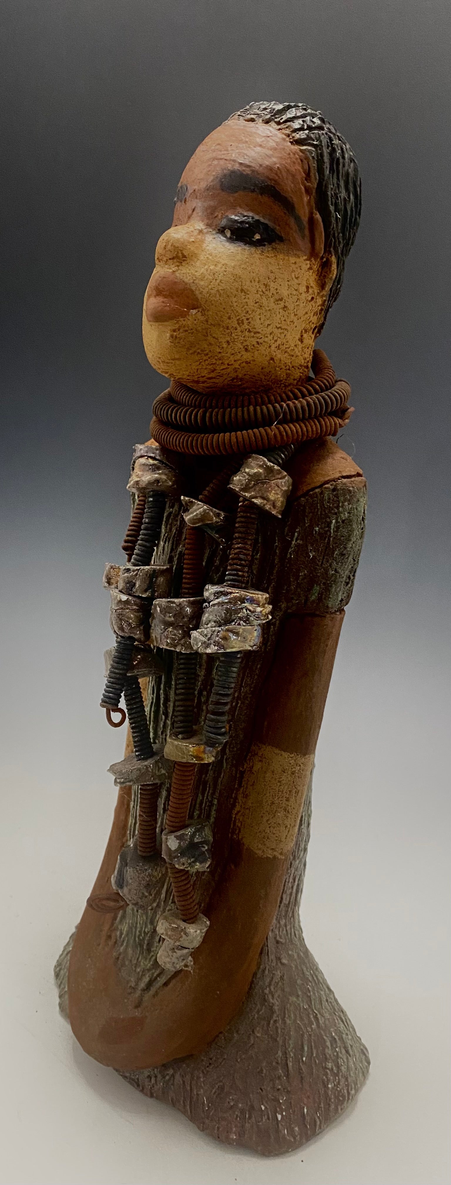 Meet Jana J! Jana J stands 13" x 6" x 5" and weighs 3.09 lbs Jana has a lovely two tone honey brown complexion. She wears a long strand of raku beads around her neck. Give Jana J in a special place in your home!