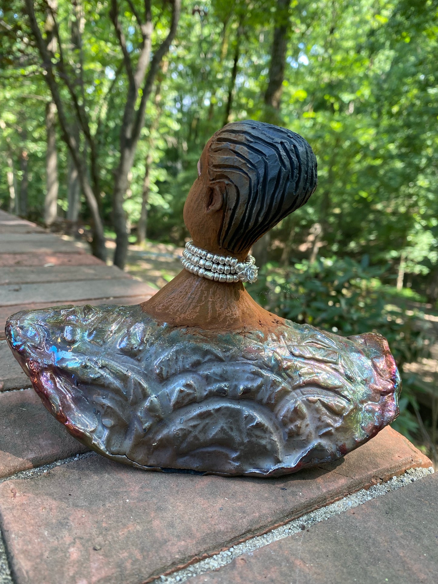 Belinda looks up with joy and anticipation! Belinda stands 6" x 8" x 4" and weighs 1.40 lbs. She has a beautiful textured copper robe trim. Belinda has braided clay hair. She has a honey brown complexion and soft light brown lips. Belinda will make for great conversation in your home.