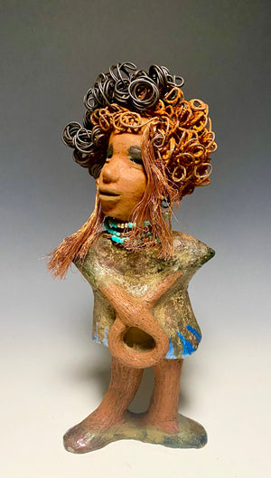 Meet Ernestine! What a joy to be around a young lady like Ernestine! She is one of many who has a polite gentle spirit! Ernestine stands 13" x 5" x 4" and weighs 3.19 lbs. Ernestine has a lovely honey brown complexion. Her hair is made of multiple strands of thin copper wire and two tone  black and rusted 16 gauge wire. She has a  textured  colorful copper metallic dress. Ernestine is a young woman full of pride and joy. If you like sophisticated  sculptures, Ernestine will bring joy and peace to your home.