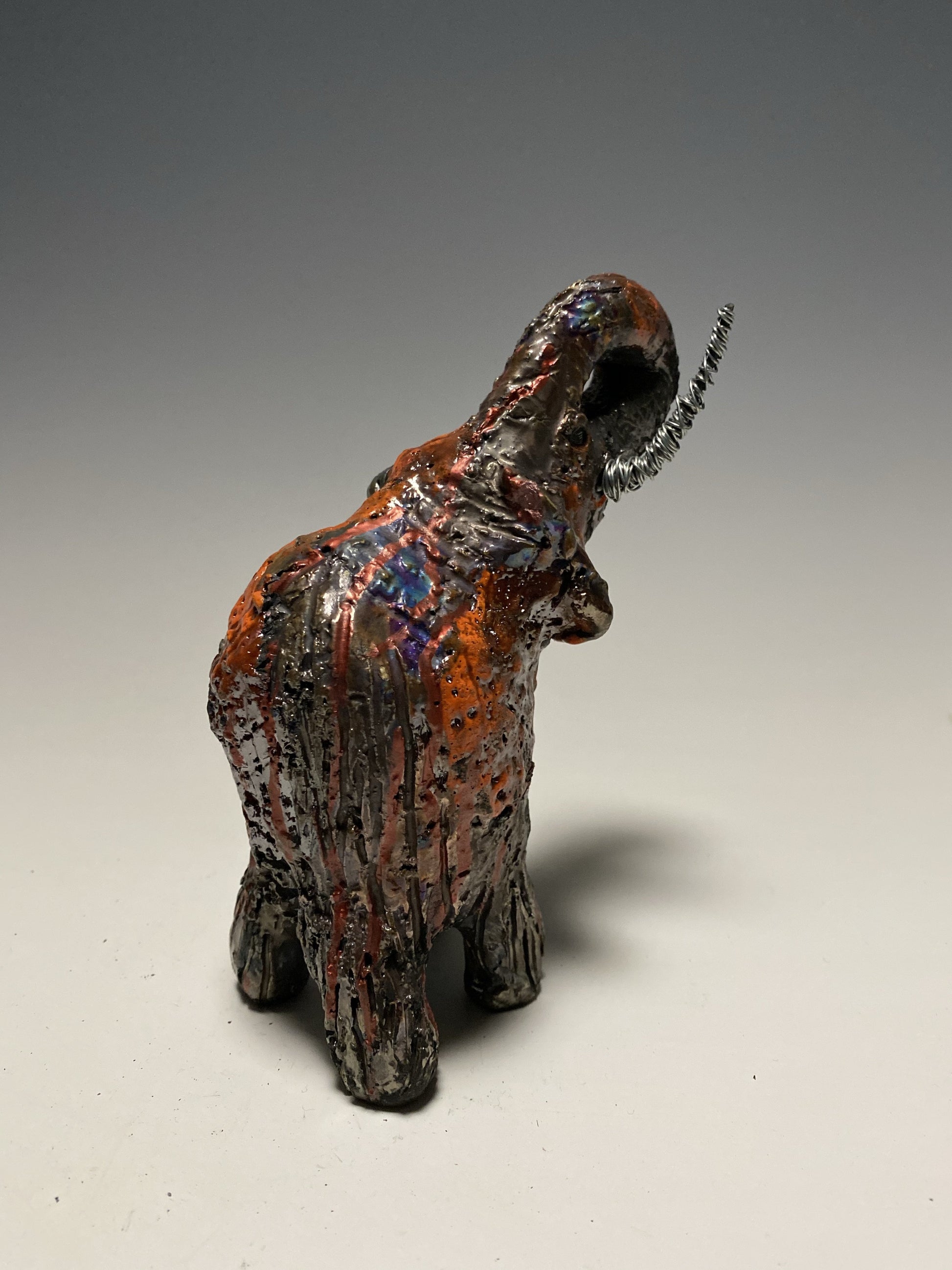 Raku Elephant Have you HERD!!!!!!  Just one of these lovely Raku Fired Elephant will make an excellent gift for your  friend, sorority or for your home’ special place centerpiece.   6" x 3" x 4" 11 ozs. Beautiful metallic orange raku elephant For decorative purposely only