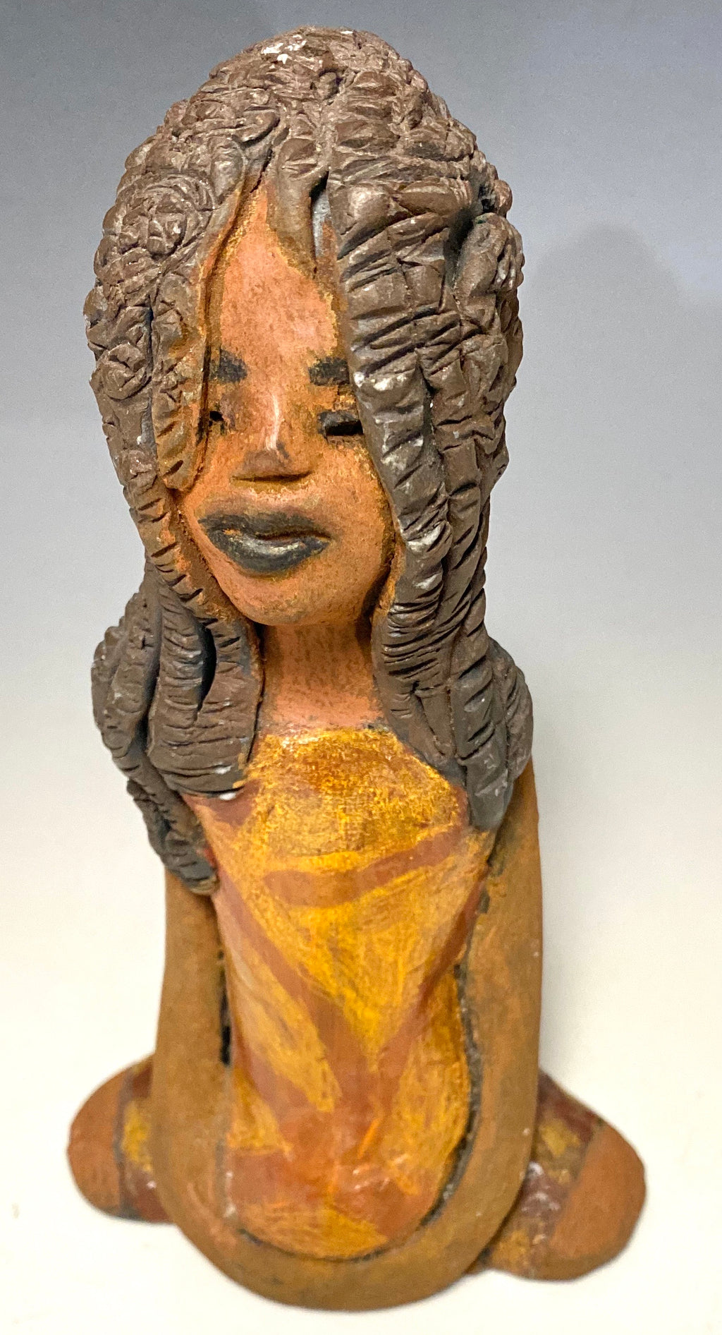 Meet Bree! Bree stands 7.5' x 4.5" x 2.5" and weighs 11 ozs. She has a lovely honey brown complexion. Bree wears a golden brown striped dress. Her hair is smokey black .and made of clay. Bree's long loving arms rest at her side.