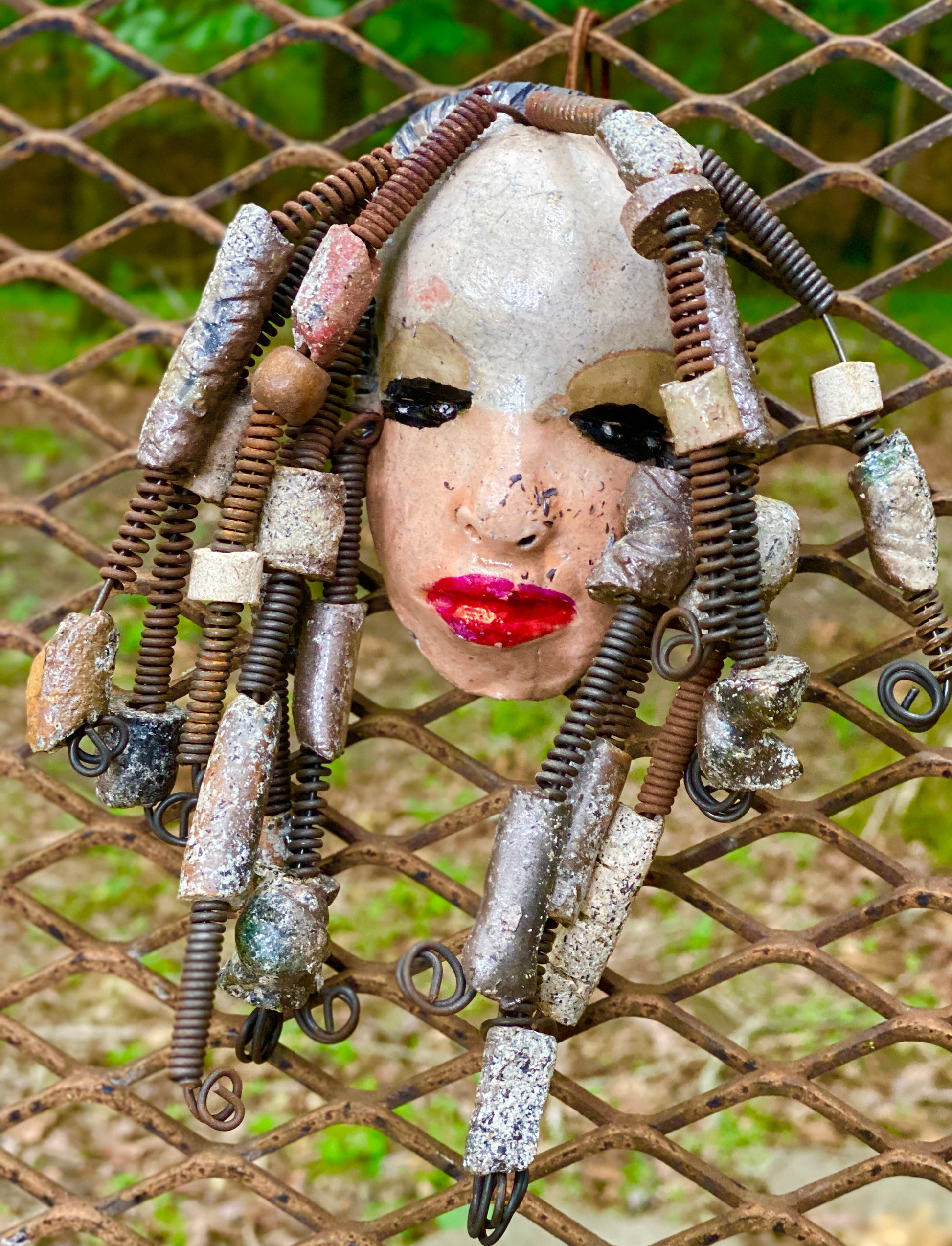 I started making art soon after seeing authentic African artwork at the Smithsonian Museum of African Art. I was in total awe. Ireland was inspired by my visit there.  Ireland weighs 13 ozs. Her face is formed with hand coiled wire and raku beads Ireland's  face  is two tone and beams with pale pink crackle glaze and ruby red lips.