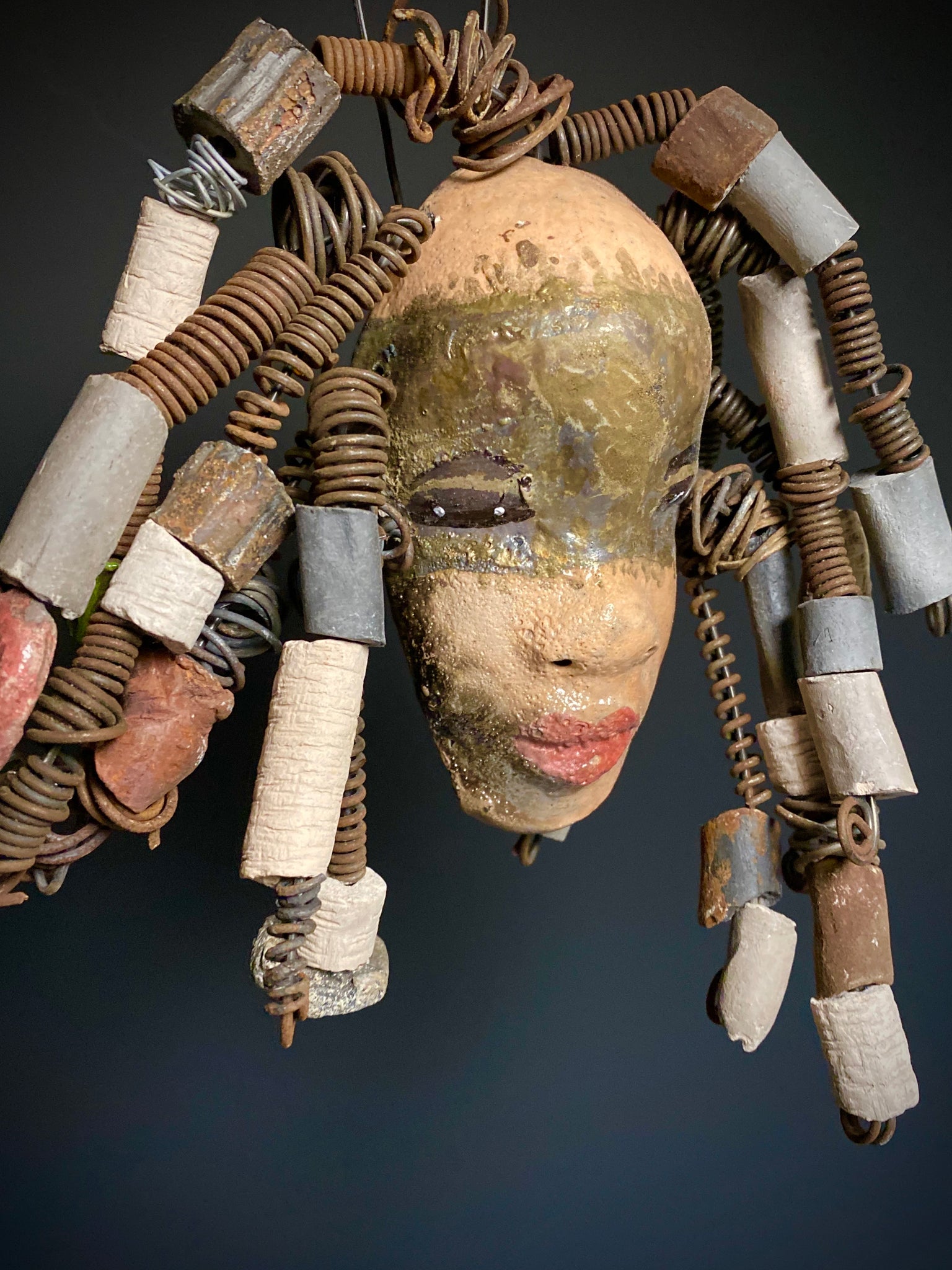 I started making art soon after seeing authentic African artwork at the Smithsonian Museum of African Art. I was in total awe. Kia was inspired by my visit there.   Kia has a light and dark honey brown complexion. Her hair can be adjusted up to  11" x 10" and weighs 1.09 lbs Kia has  over 20 handmade multicolored raku fired beads. She has over 20 feet of coiled 16 gauge wire hair. Kia is ready for display!