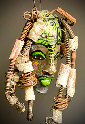 I started making art soon after seeing authentic African artwork at the Smithsonian Museum of African Art. I was in total awe. This work was inspired by my visit there.  Meet the Green Man! The Green Man is   5"x 6". He has green and black horizontal stripes with bright eyes and green lips. He has hand coiled 16 gauge wire  hair with over  10 raku beads.