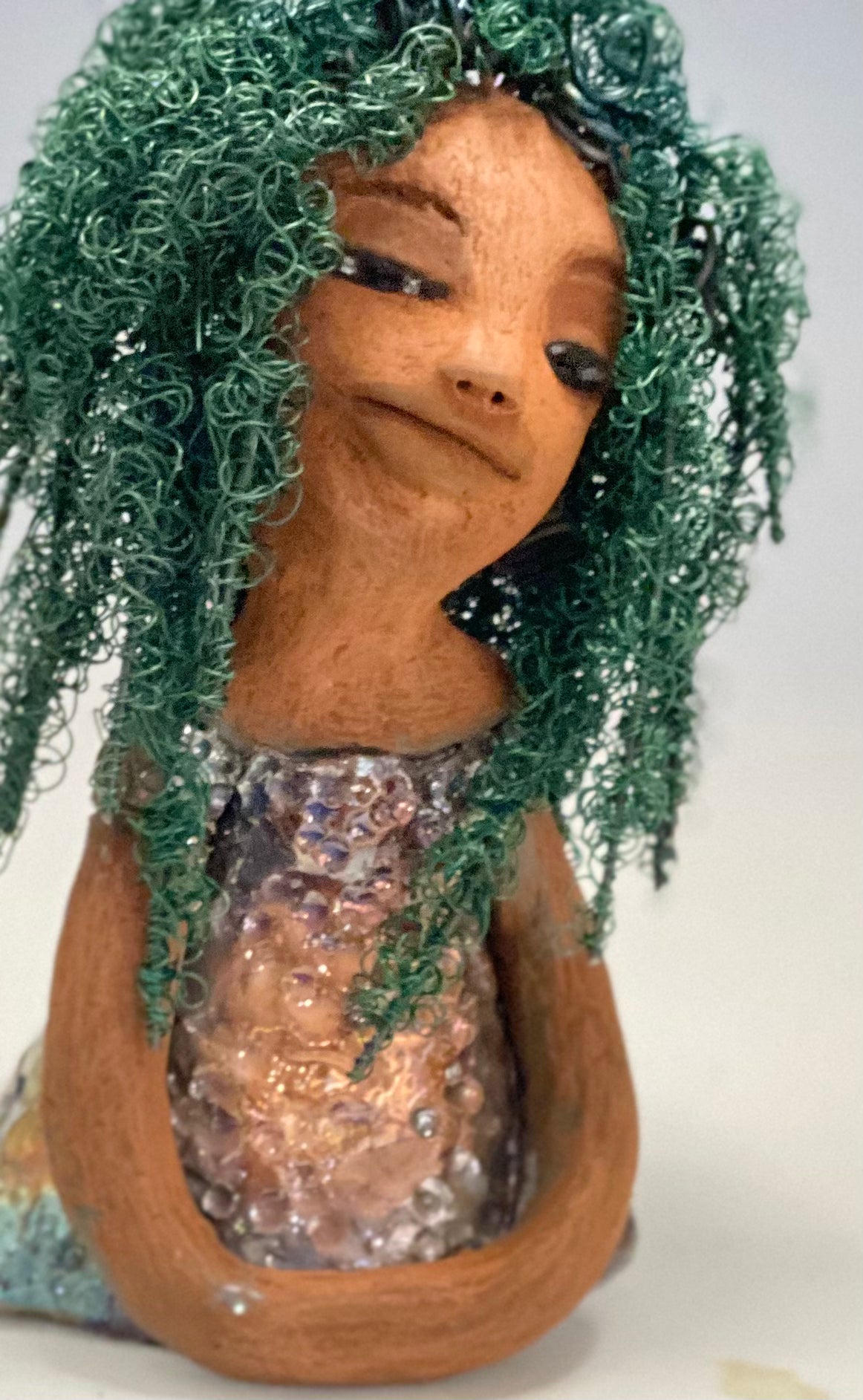 Nia Nia stands 8" x 5" x 5.5" and weighs 1.04 lbs. She has a lovely honey brown complexion with soft brown lips. She has long twisted wire locs hairstyle waist down!  Nia has a glossy metallic copper glazed dress. She has over 75 feet of 16 and 24 gauge emerald green wire for hair. It really took over 6 hours just to twist and do her hair! With  eyes wide opened, Alexis has hope of finding a new home.   