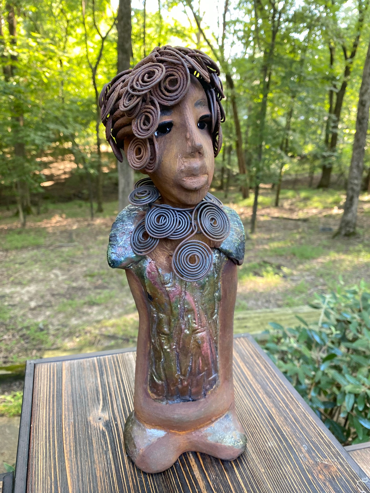 Meet Farida! Farida stand 13”x 5” x 4” and weighs 4 lbs. She has a bright eyes and a beautiful honey brown complexion. Farida has a fancy over the top Herdew. It took two hours to complete! A spiral 16 gauge necklace wraps around her neck. Her dress is a textured metallic green. Farida is looking for a new home.She would make a great gift to a BFF or just for YOU!