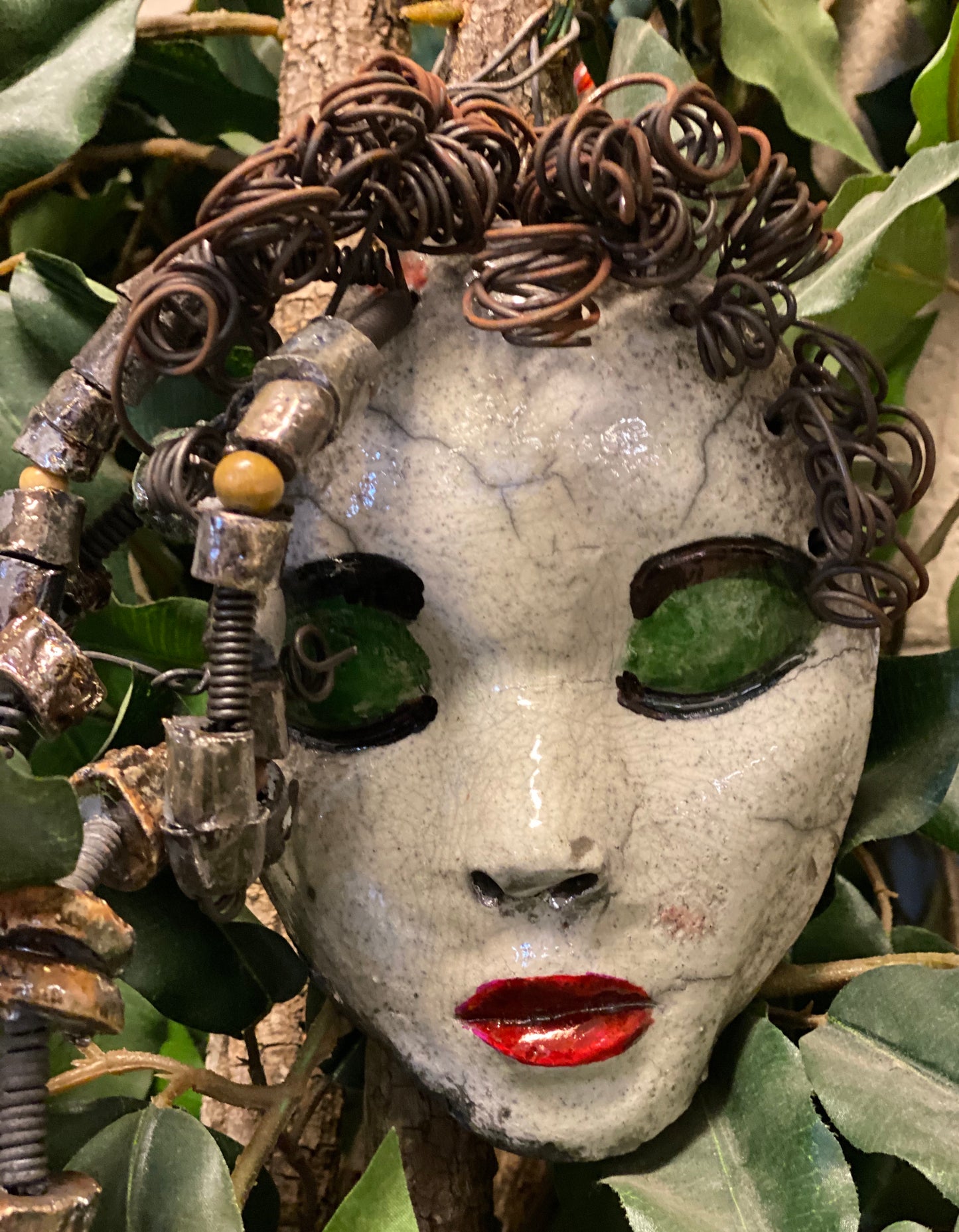 Mckenzie has a white complexion, green eye shadow, and ruby red lips! She is 7”x 5”" and weighs 1.8 lbs. Mckenzie  has over 20 handmade raku fired beads. She has over 20 feet of coiled 16 gauge wire hair.