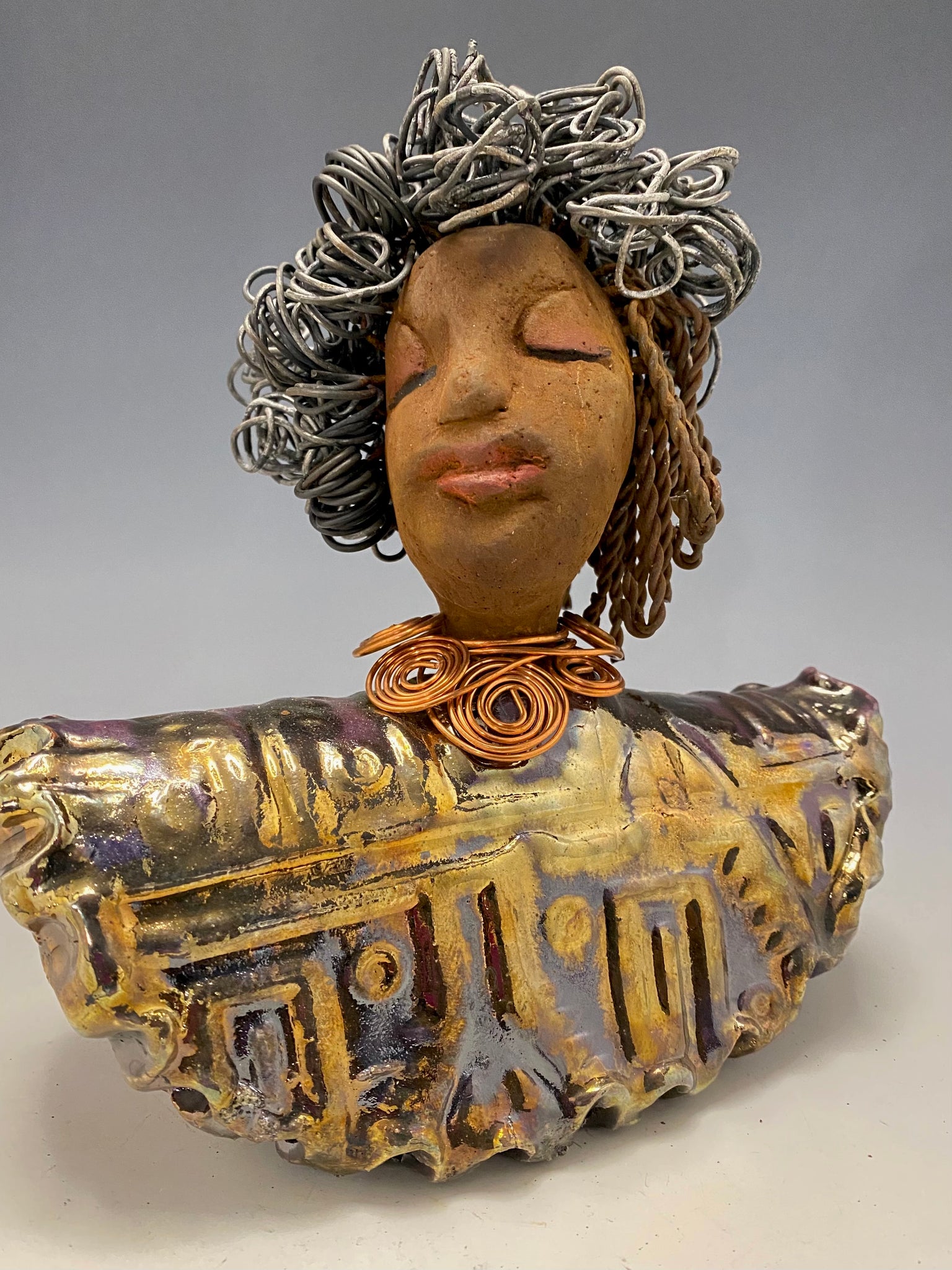 Meet Janet!  Janet looks up with joy and anticipation! She  stands 8" x 7" x 4" and weighs 2.70 lbs. She has a beautiful textured gold and  copper robe trim. Janet has braided ,twisted, and curled wire hair. She has a honey brown complexion and soft reddish brown lips. Janet will make for great conversation in your home.