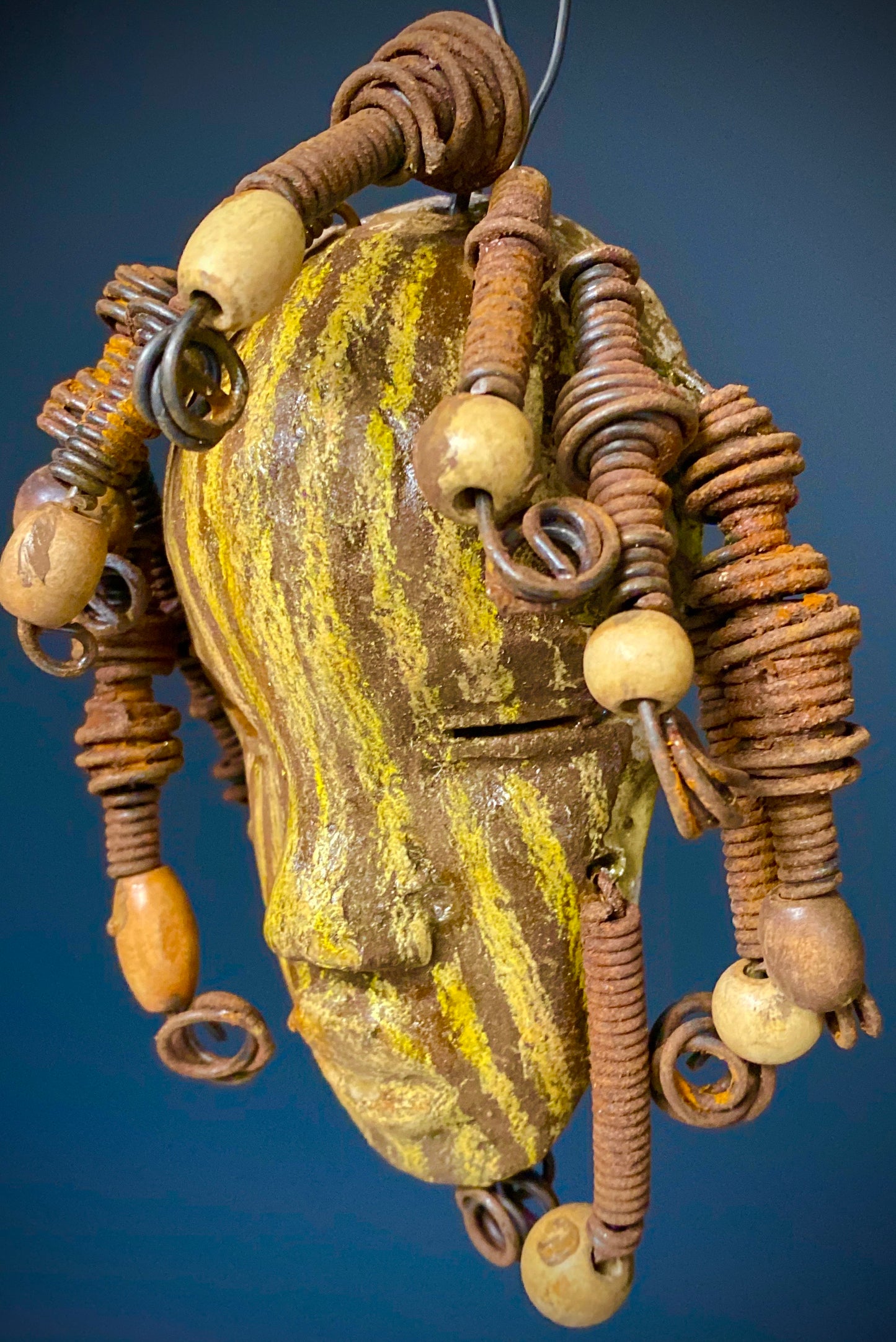 I started making art soon after seeing authentic African artwork at the Smithsonian Museum of African Art. I was in total awe.  Kaba was inspired by my visit there.   Kaba has a two tone  striped complexion of earthy gold and brown. He is 5" x 7” and weighs 1 lbs. Kaba has over 10 wooden beads. He has over 10 feet of coiled 16 gauge wire hair. If for some reason Kaba does not fit in your home, send him back for a full refund!