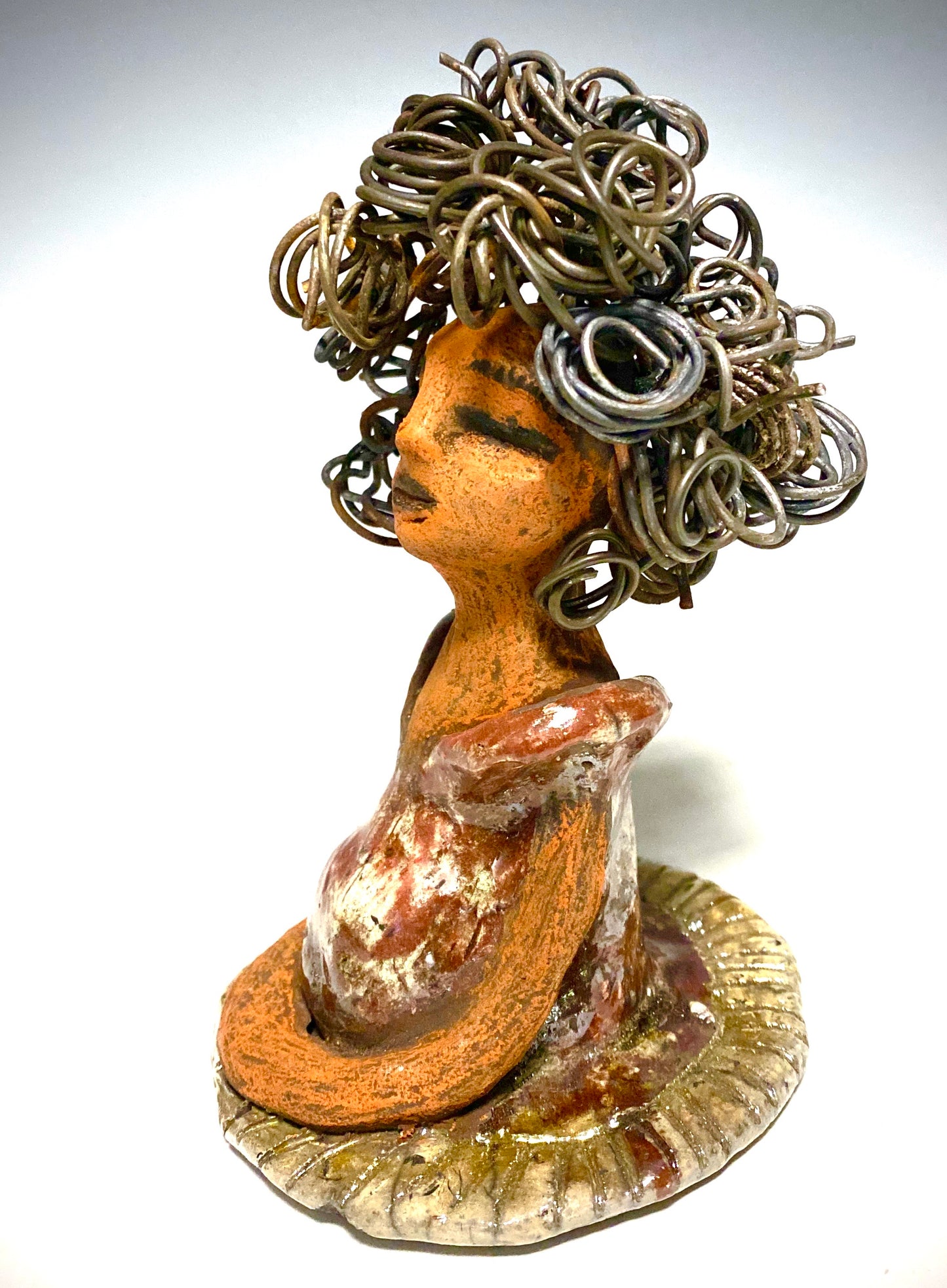 Meet Carleen! Carleen  stands 6" x 4" x 4" and weighs 12 ozs. Carleen has a honey brown complexion with 16 gauge curled wire hair. She wears an copper metallic dress. Carleen  has her long loving arms at her side as she rest and waits.