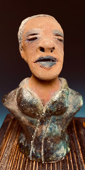 Mr. Charles has a story to tell!  Do you See the wisdom in his face? Mr. Charles  stands 5"x 3" x 2.5" and weighs 11 ozs.   Mr. Charles wears a copper green metallic jacket. His complexion is honey brown  Mr Charles has aged salt and pepper hair!