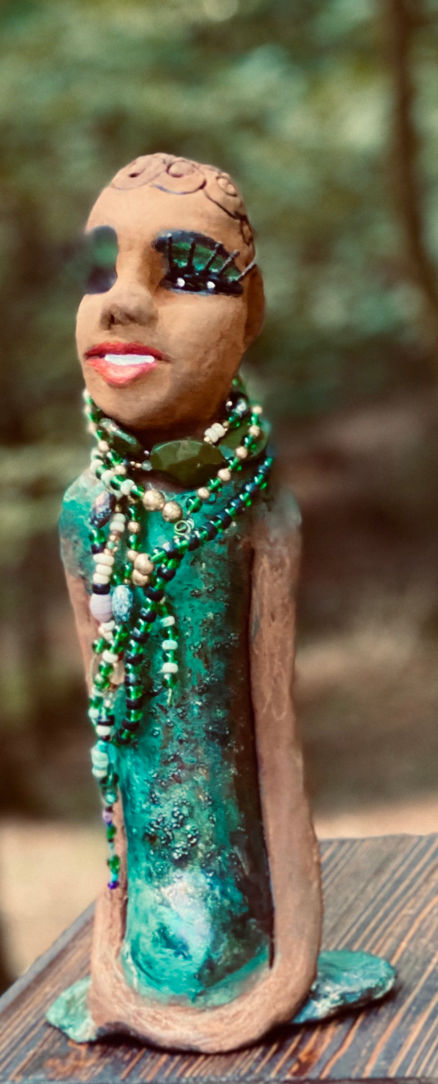 Meet Makeda What a joy to be around Makeda! She is one of many who has a polite gentle spirit! Makeda 12" x 6" x 4" and weighs 1.1 lbs. Makeda has a lovely honey brown complexion. Her  hair is made of textured clay. She has very loooong eyelashes! She has a  copper green metallic dress. Makeda Is a a young  lady full of pride and joy. If you like sophisticated  sculptures, Makeda will bring joy and peace to your home.