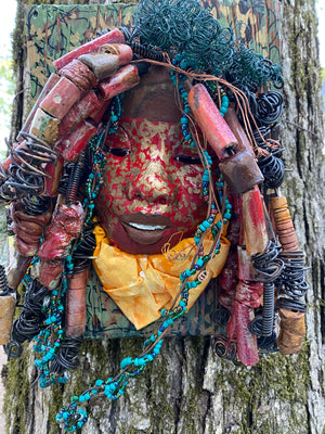 Deandra is one of a new 2022  series of tribal masks that are mounted on wood. I started making art soon after seeing authentic African artwork at the Smithsonian Museum of African Art. I was in total awe. Deandra is 7” x 10 x 1 and weighs 3.7 lbs.  She has a contagious smile. 25 handmade raku fired beads Over 60 mini 6mm multi colored beads  Over 60 feet of 16 and 24 gauge twisted wire for hair!