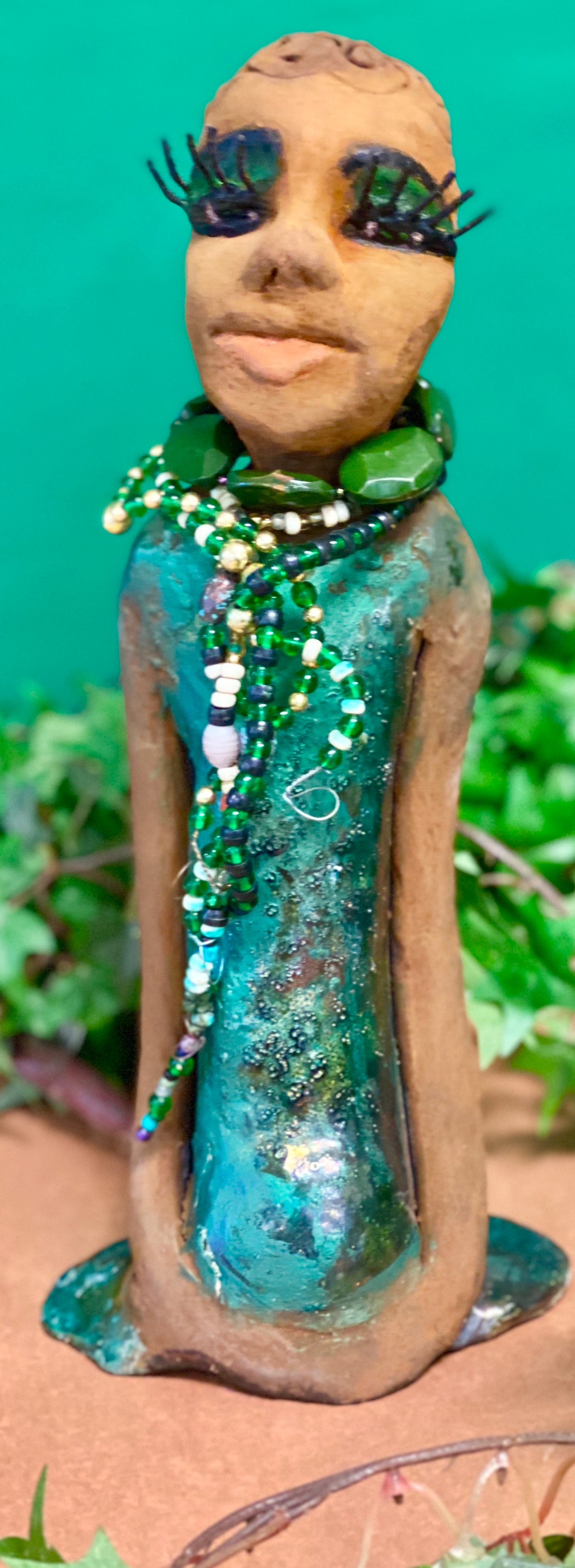 Meet Makeda  What a joy to be around Makeda! She is one of many who has a polite gentle spirit! Makeda 12" x 6" x 4" and weighs 1.1 lbs. Makeda has a lovely honey brown complexion. Her  hair is made of textured clay. She has a  copper green metallic dress. Makeda Is a a young  lady full of pride and joy.