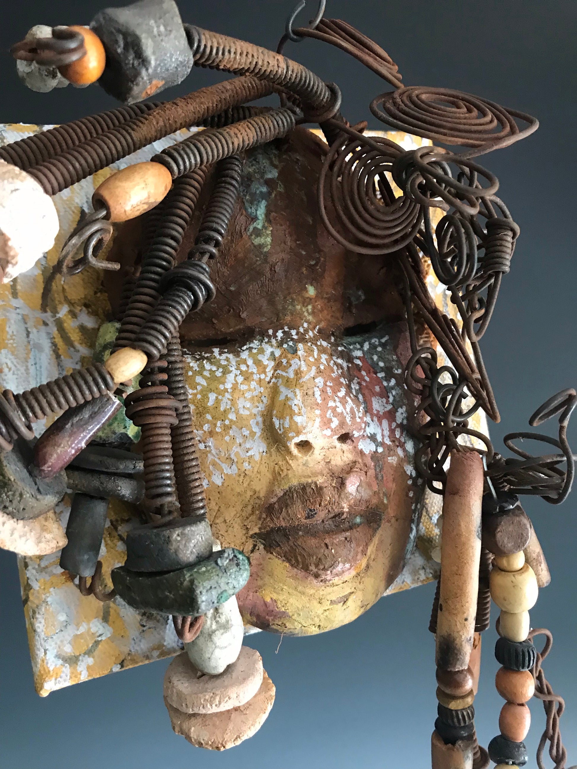      Iowa is uniquely mounted on a painted 6"x 4"x 2" canvas. It weighs 1.13 lbs.     Her face has white dots over an earthy.glaze with dark brown lips.     Iowa has  hand coiled wire, multi color raku beads,wood beads, and textured earthy cloth..  Iowa is ready to be hung!