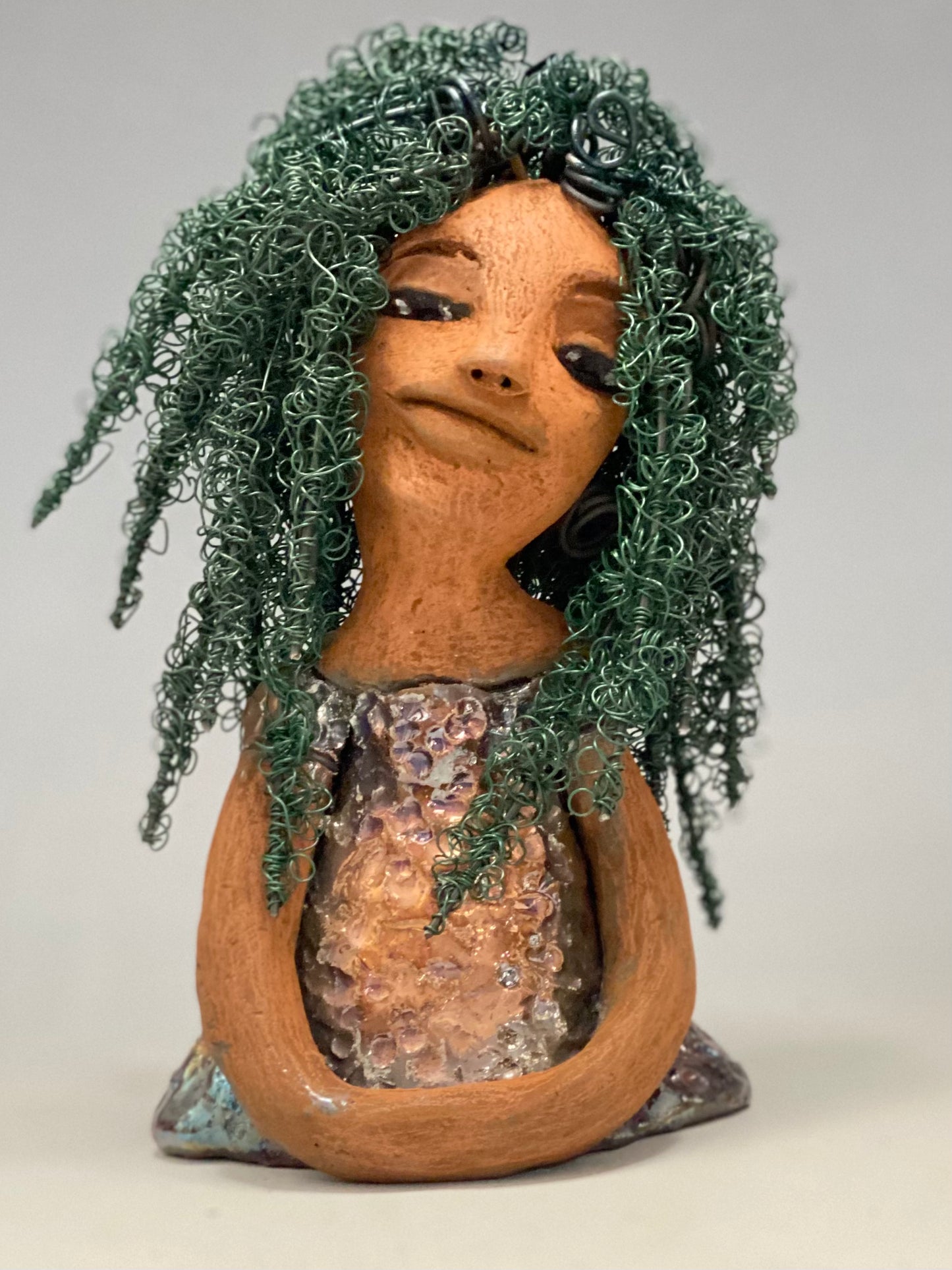 Nia Nia stands 8" x 5" x 5.5" and weighs 1.04 lbs. She has a lovely honey brown complexion with soft brown lips. She has long twisted wire locs hairstyle waist down!  Nia has a glossy metallic copper glazed dress. She has over 75 feet of 16 and 24 gauge emerald green wire for hair. It really took over 6 hours just to twist and do her hair! With  eyes wide opened, Alexis has hope of finding a new home.   
