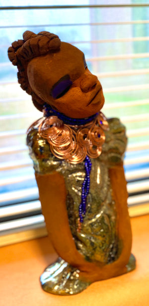 Georgia stands 11" x 5" x 3" and weighs 2.15 lbs. She has a honey brown complexion with a braided tribal clay hairstyle. She has an awesome copper metallic glitzy dress. Georgia has her long loving arms folded as she rest and waits.  Give  Georgia special place inside of your home.