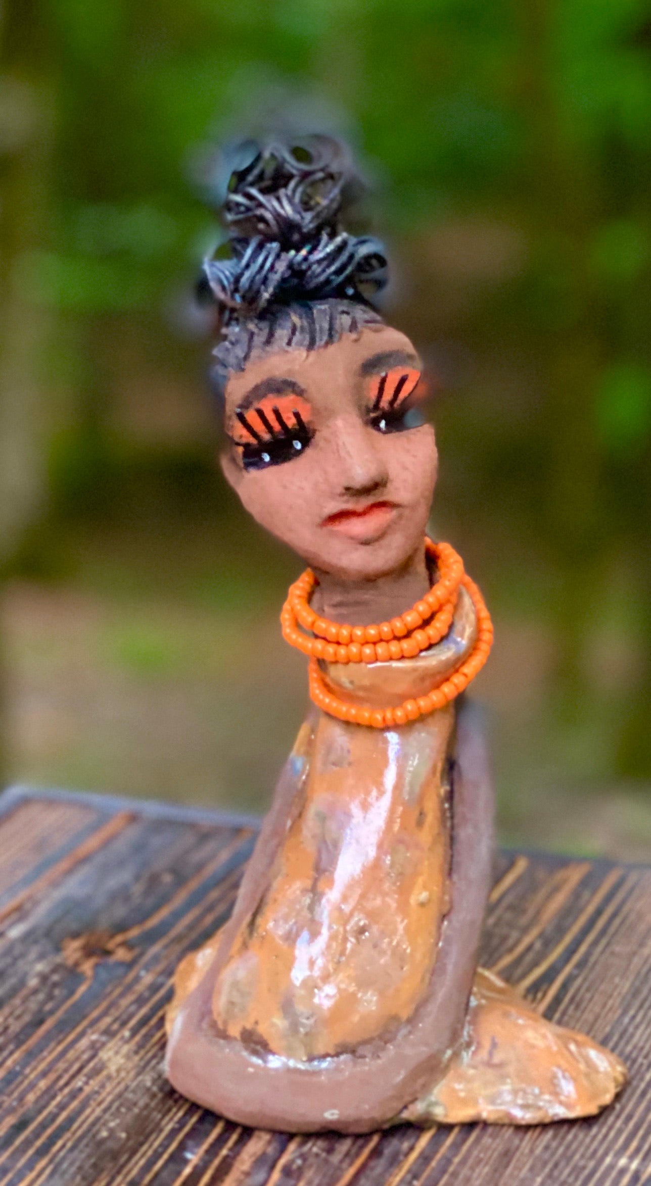 Meet Abimbola ! Abimbola stands 7' x 4"x 2" and weighs 1.3 lb. She has bright eyes and a nice honey brown complexion Abimbola  has over 5 feet of 16 gauge wire hair wrapped in a bun. Her long trademark arms rest at her side. Abimbola dress is a loving glossy orange mix with copper flashes. Abimbola is waiting for you to invite her into your home! 