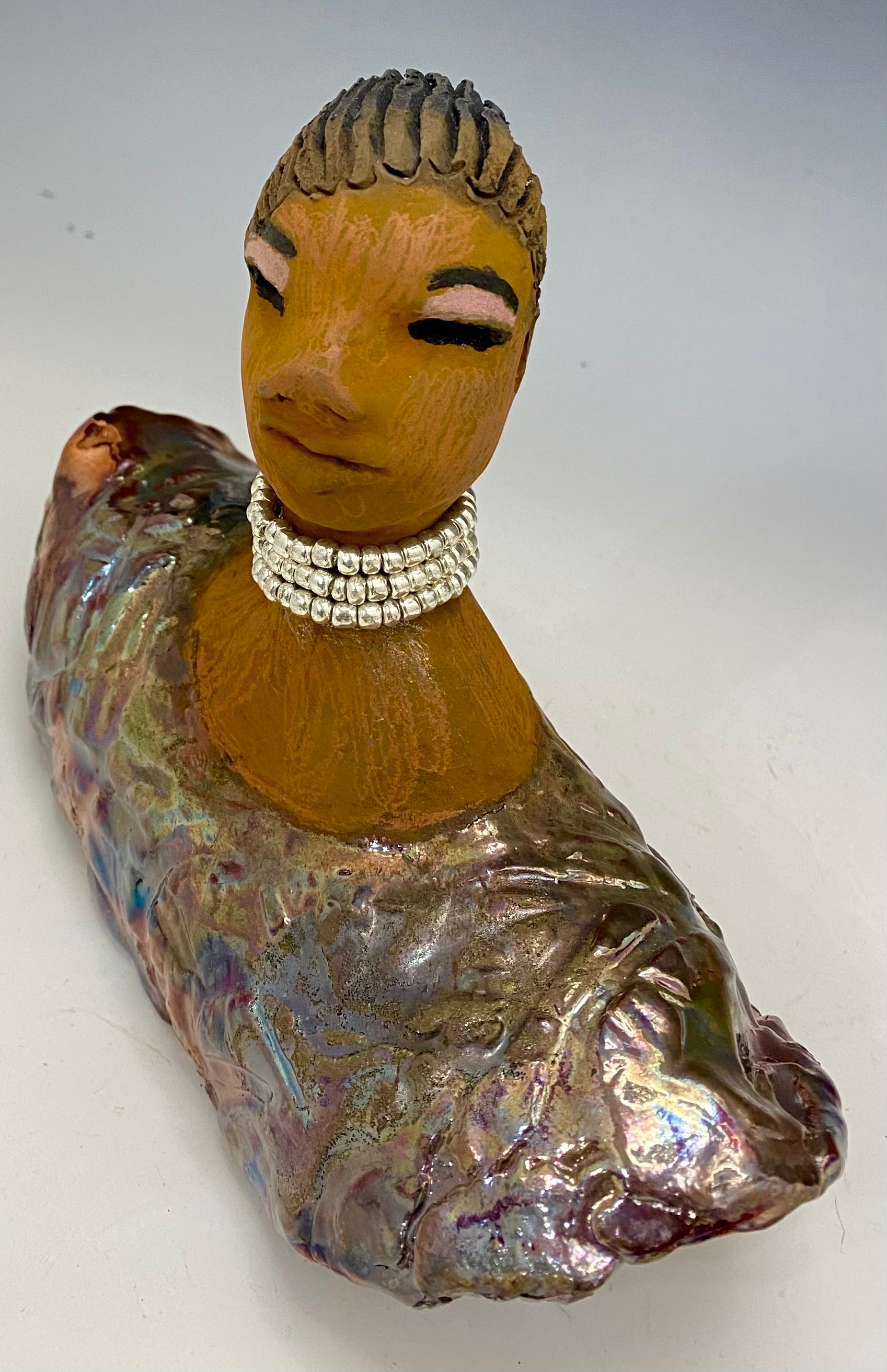 Belinda looks up with joy and anticipation! Belinda stands 6" x 8" x 4" and weighs 1.40 lbs. She has a beautiful textured copper robe trim. Belinda has braided clay hair. She has a honey brown complexion and soft light brown lips. Belinda will make for great conversation in your home.