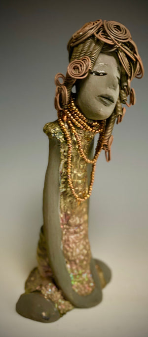 Meet Carolyn! Carolyn stands 12" x 6" x 4" and weighs 2.4 lbs. Carolyn as a lovely smokey dark complexion with honey brown eye shadow.' She wears a textured glossy copper metallic dress. Carolyn's long loving arms are at her side. It took three hours to complete her 16 gauge wire Herdew! Give Carolyn a special place in your home