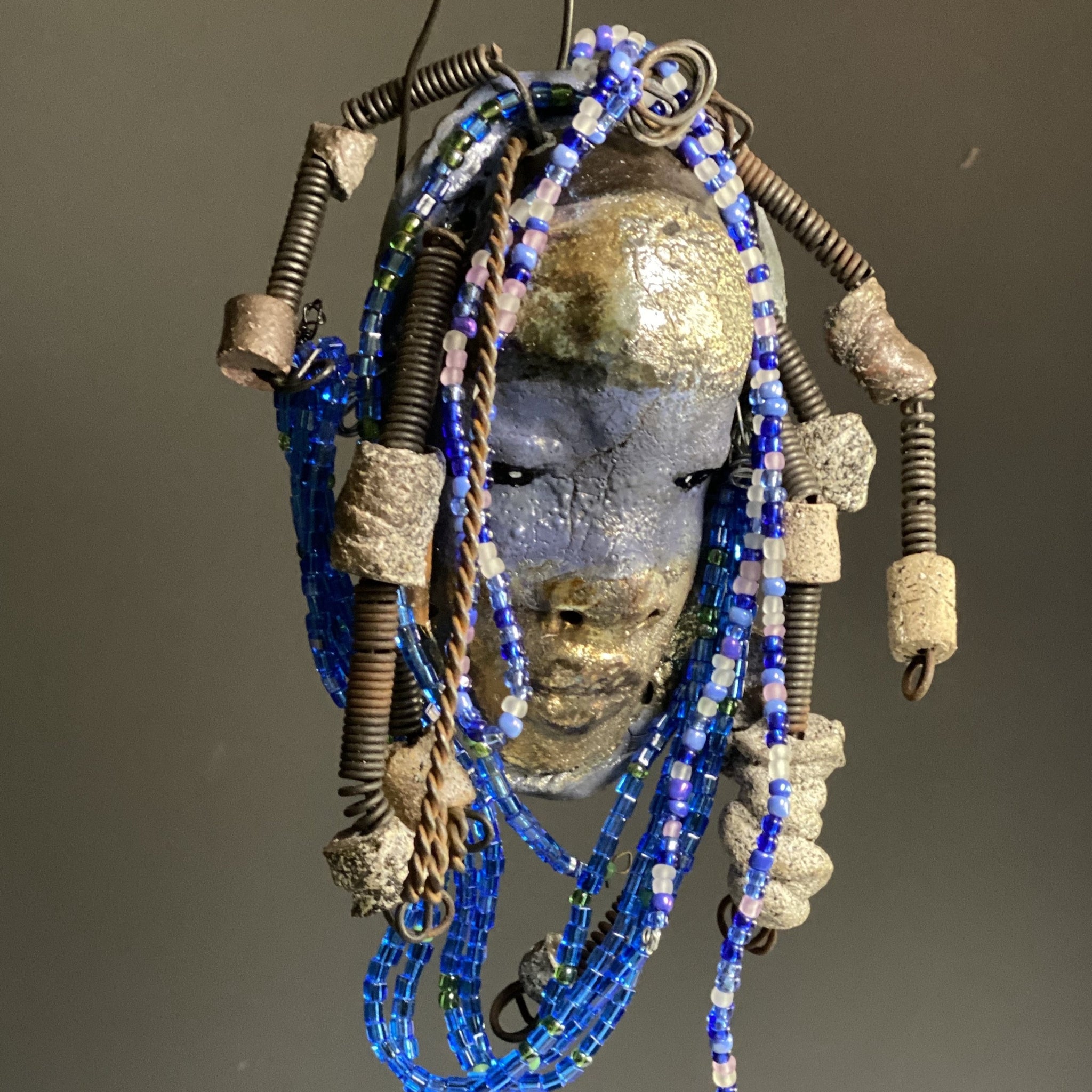  Meet Randi! I started making art soon after seeing authentic African artwork at the Smithsonian Museum of African Art. I was in total awe. Randi was inspired by my visit there.   Randi has a two tone complexion of golden silver and blue. She is 8" x 6" and weighs 14 ozs. Randi has over 10 raku beads. She has over 200 of multi shade of blue and white mini beads. Randi has over 10 feet of  coiled copper and 16 gauge wire hair.