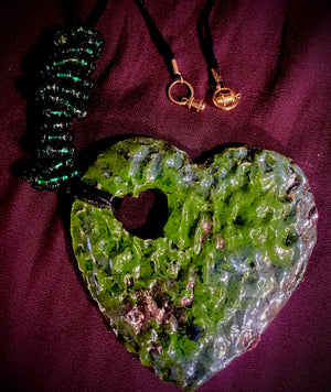 Have A Heart ! Each heart pendant is handmade with love! It is 3"x 3" and weighs approx. 3ozs. This pendant has a green and copper metallic raku glazes that renders a unique translucent  patina. The heart has a textured pattern . Both sides are  are different and equally beautiful! It holds a spiral of multicolored mini beads on a spiral golden wire. This pendant has a nice 12" black rattail cord!
