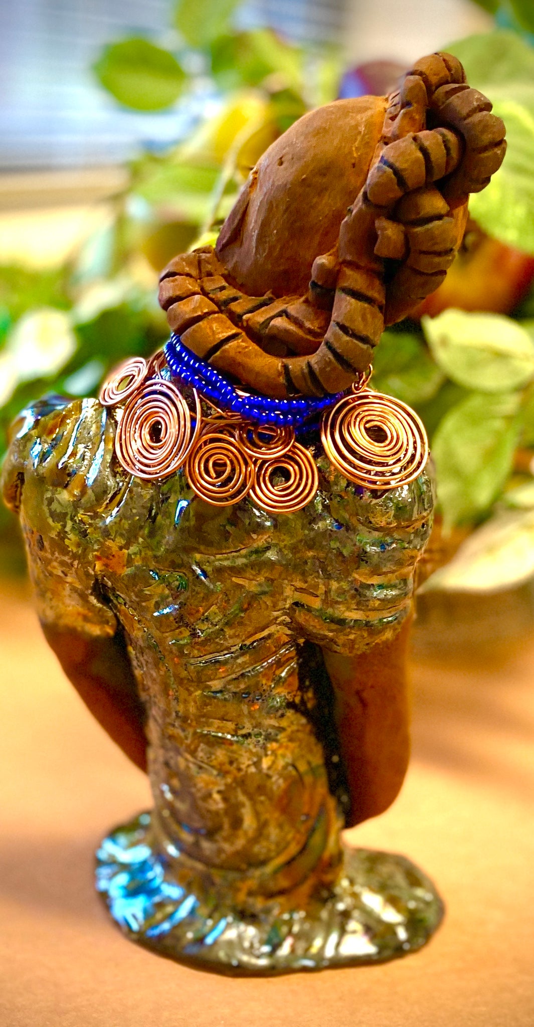 Georgia stands 11" x 5" x 3" and weighs 2.15 lbs. She has a honey brown complexion with a braided tribal clay hairstyle. She has an awesome copper metallic glitzy dress. Georgia has her long loving arms folded as she rest and waits.  Give  Georgia special place inside of your home.