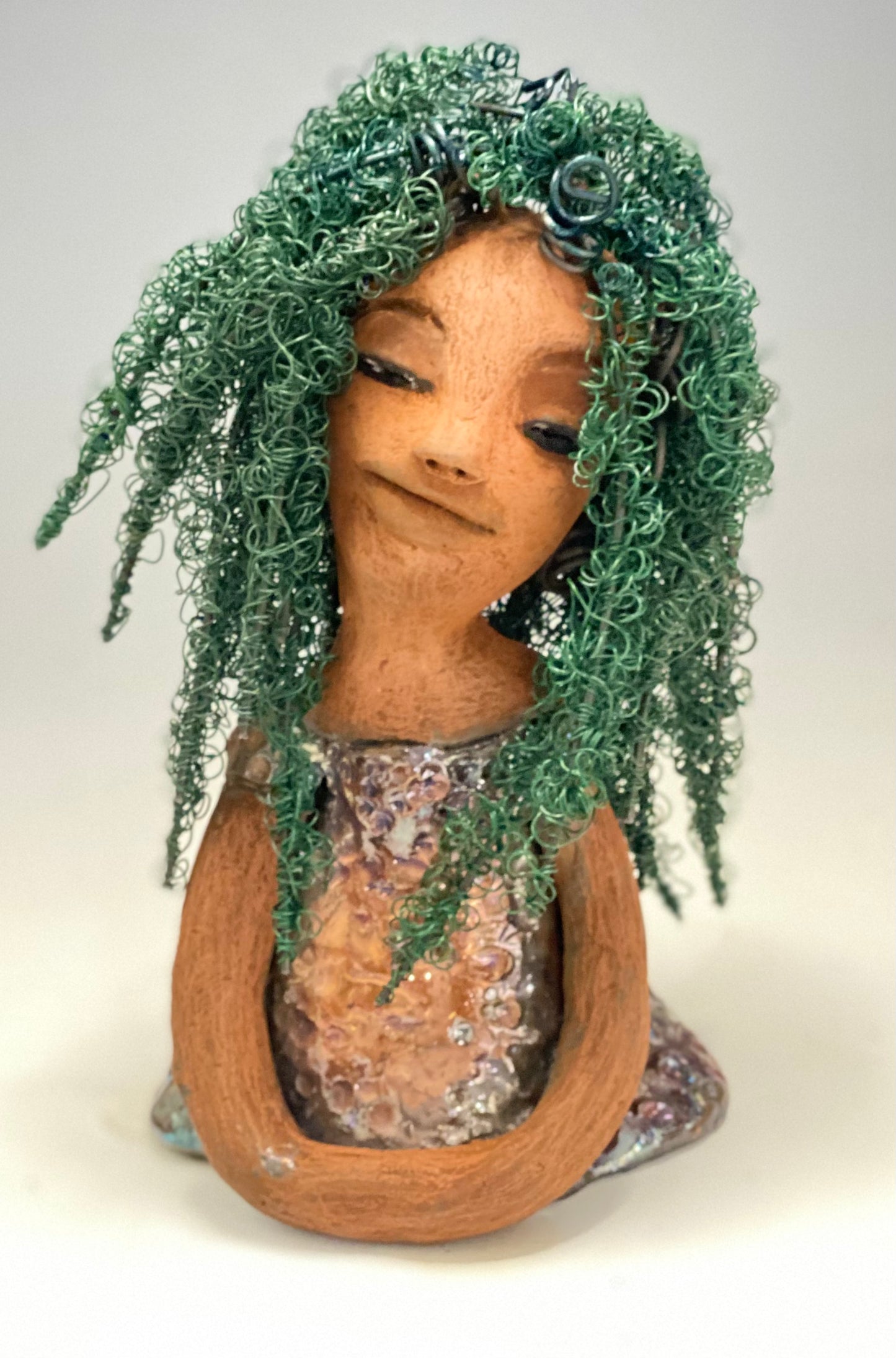 Nia Nia stands 8" x 5" x 5.5" and weighs 1.04 lbs. She has a lovely honey brown complexion with soft brown lips. She has long twisted wire locs hairstyle waist down!  Nia has a glossy metallic copper glazed dress. She has over 75 feet of 16 and 24 gauge emerald green wire for hair. It really took over 6 hours just to twist and do her hair! With  eyes wide opened, Alexis has hope of finding a new home.   