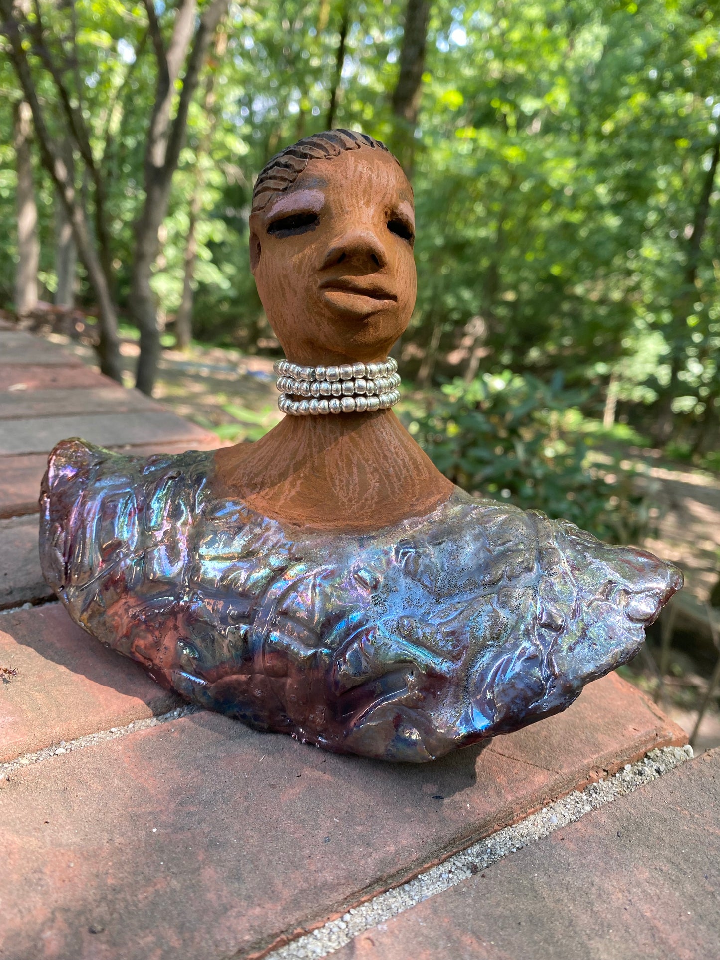 Belinda looks up with joy and anticipation! Belinda stands 6" x 8" x 4" and weighs 1.40 lbs. She has a beautiful textured copper robe trim. Belinda has braided clay hair. She has a honey brown complexion and soft light brown lips. Belinda will make for great conversation in your home.