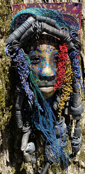 Aamadu is one of a new 2023 series of tribal masks that are mounted on wood. I started making art soon after seeing authentic African artwork at the Smithsonian Museum of African Art. I was in total awe.   Aamadu  is 4.5” x 8 x 1 and weighs 1.13 lbs.  He has a contagious smile. Aamadu's face is speckled. Over 20 handmade raku fired beads  Over 60 feet of 16 and 24 gauge twisted wire for hair! Over two weeks to complete! Aamadu is ready to be mounted inside or outdoors!
