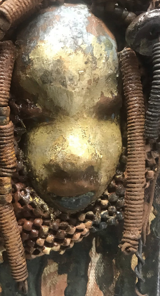 "I started making mask after seeing an authentic African Mask collection at the Smithsonian Museum of African Art. I was in total awe. Dillan was inspired by my visit there".       Dillan is mounted on a painted 6"x 4"x 2" canvas. She weighs 15 ounces.     Her face is formed with hand coiled wire, multiple raku, and wood beads, matte textured  and brown cloth.     Dillan's face beams with  almond  green glaze and rust blue brown lips.     Dillan is ready to be hung.