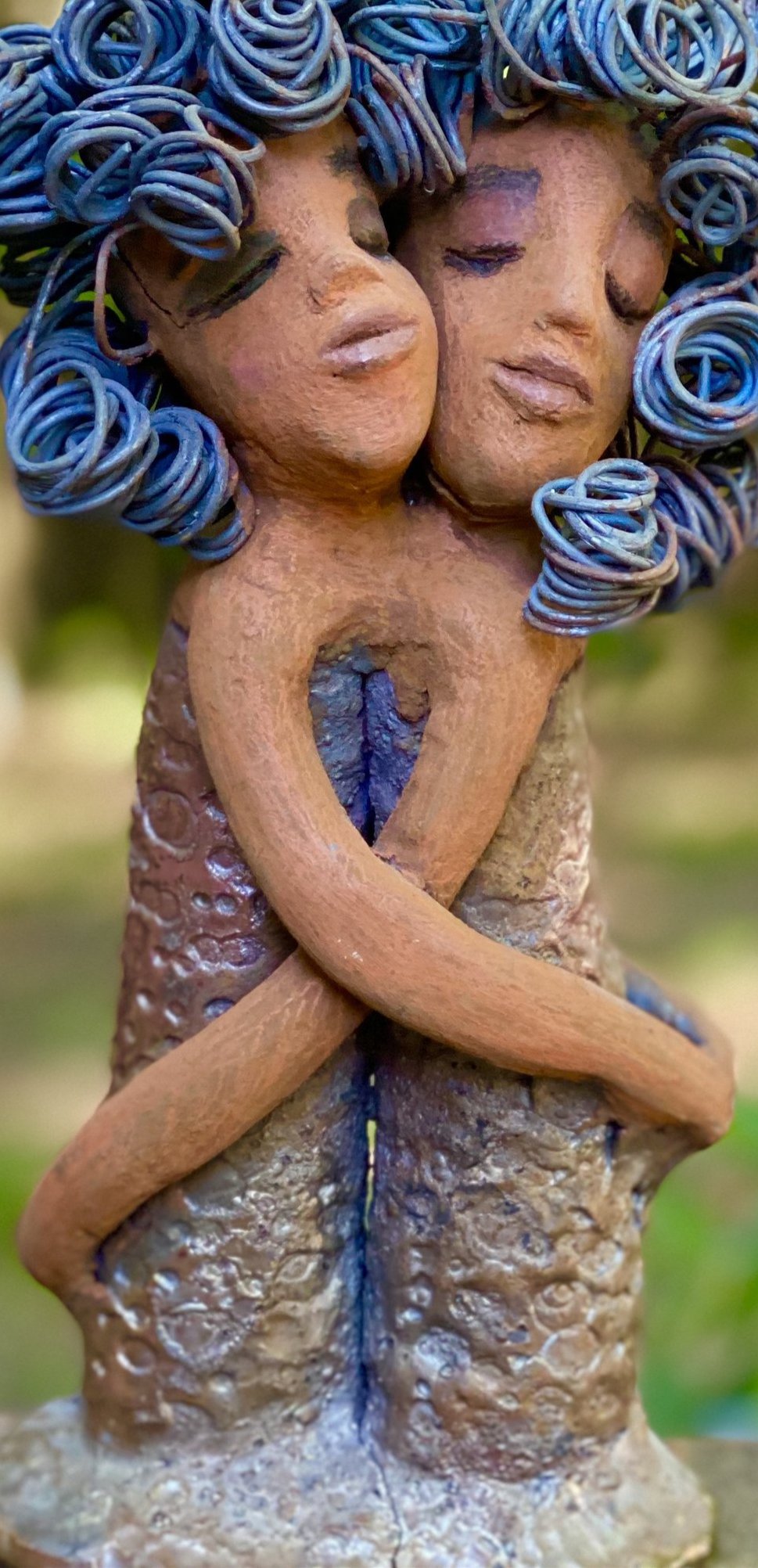 Sister Love is a raku fired sculpture. Raku is a specialized firing technique that involves high heat and open flames. Sister Love stands 11" x 5" x 3" and weighs 2.06 lbs﻿. Combined they have over 45 feet of curled 16 gauge wire hair. The dresses are textured with an antique copper glaze. They have lovely honey brown complexions and long loving arms. Sister Love is inseparable! Give them a special place in your home. Free Shipping!
