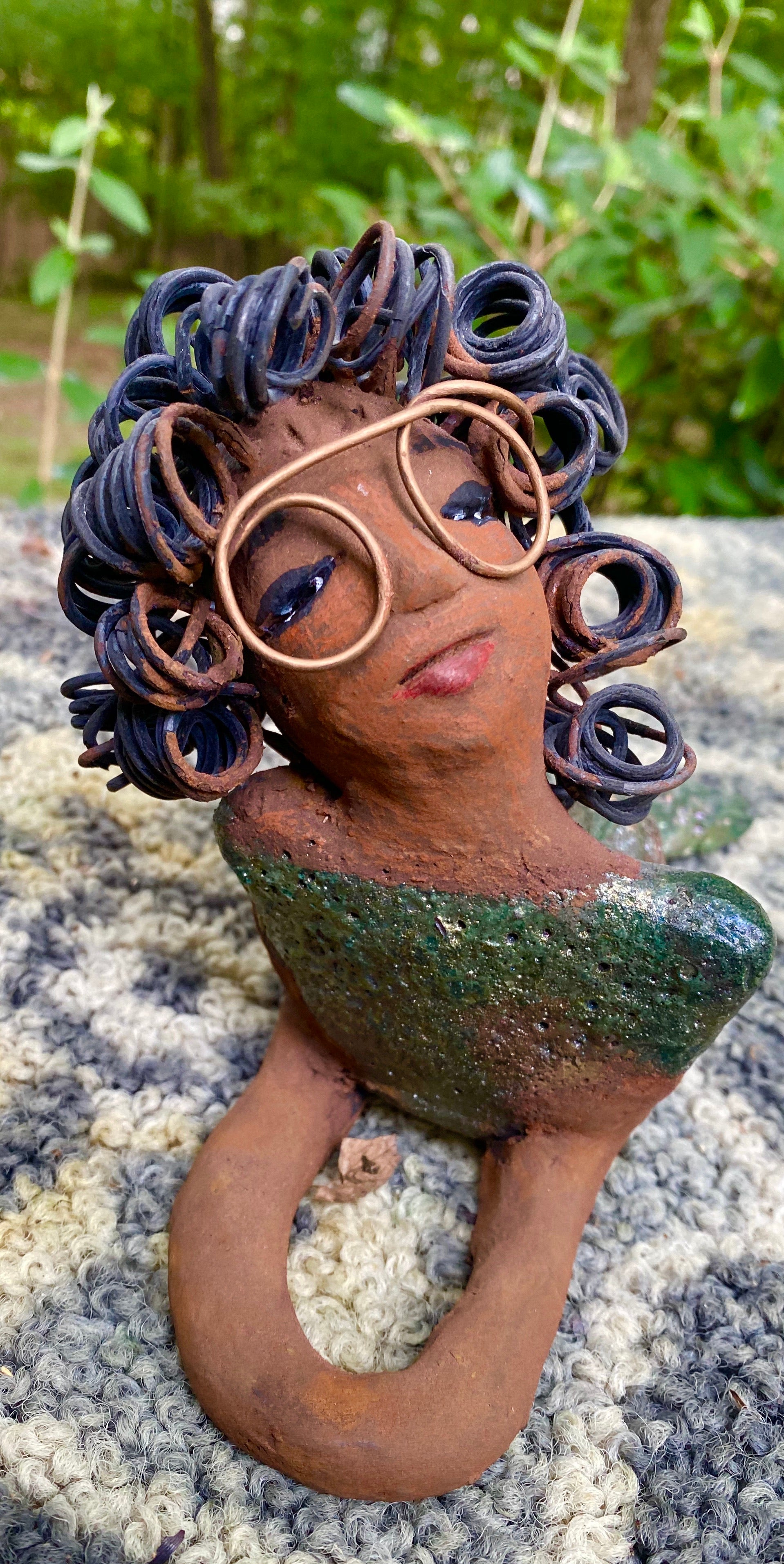 Meet Elma the Mermaid !﻿ Elma stands 6" x 8" x 4" and weighs 1.07 lbs. Elma has a lovely honey brown complexion. Elma's body has a copper green metallic glaze She has over 25 feet of curly wire hair. Elma looks up in anticipation of being a part of your home!