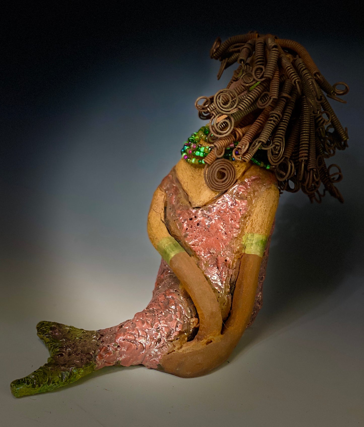 "Honestly, I can not explain where this desire to make mermaids come from. When I created my first raku fired mermaid, I was amazed at how well my homemade metallic copper green glaze worked with the mermaid's body suit. It was a good match with the honey brown complexion I use with most of my sculptures".  Compare Meranda with Melody the mermaid.