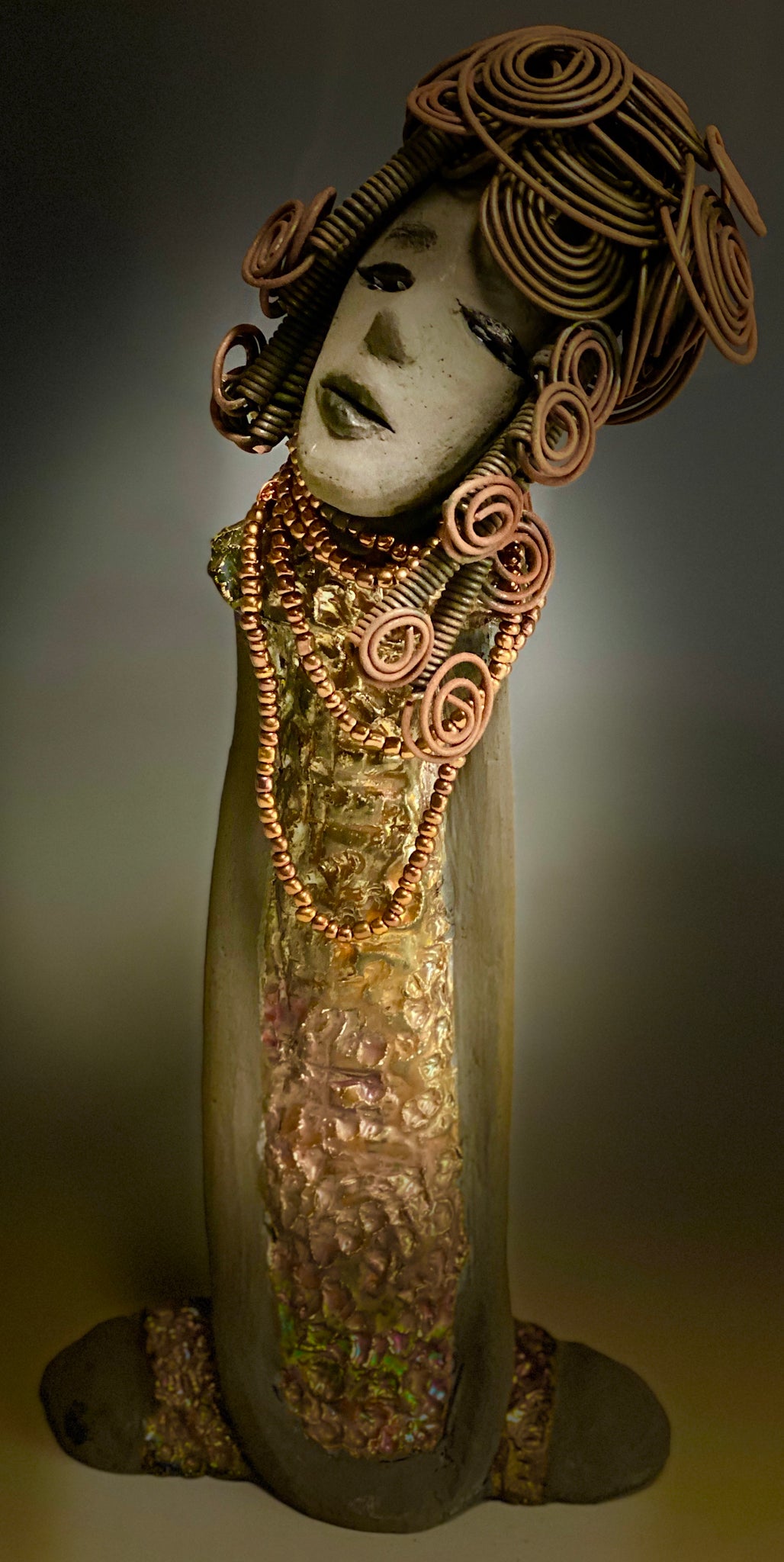 Meet Carolyn! Carolyn stands 12" x 6" x 4" and weighs 2.4 lbs. Carolyn as a lovely smokey dark complexion with honey brown eye shadow.' She wears a textured glossy copper metallic dress. Carolyn's long loving arms are at her side. It took three hours to complete her 16 gauge wire Herdew! Give Carolyn a special place in your home