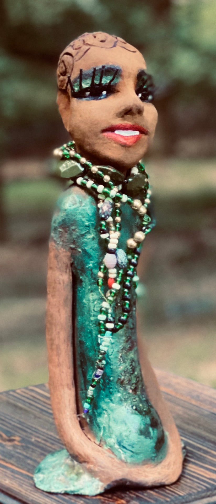 Meet Makeda What a joy to be around Makeda! She is one of many who has a polite gentle spirit! Makeda 12" x 6" x 4" and weighs 1.1 lbs. Makeda has a lovely honey brown complexion. Her  hair is made of textured clay. She has very loooong eyelashes! She has a  copper green metallic dress. Makeda Is a a young  lady full of pride and joy. If you like sophisticated  sculptures, Makeda will bring joy and peace to your home.