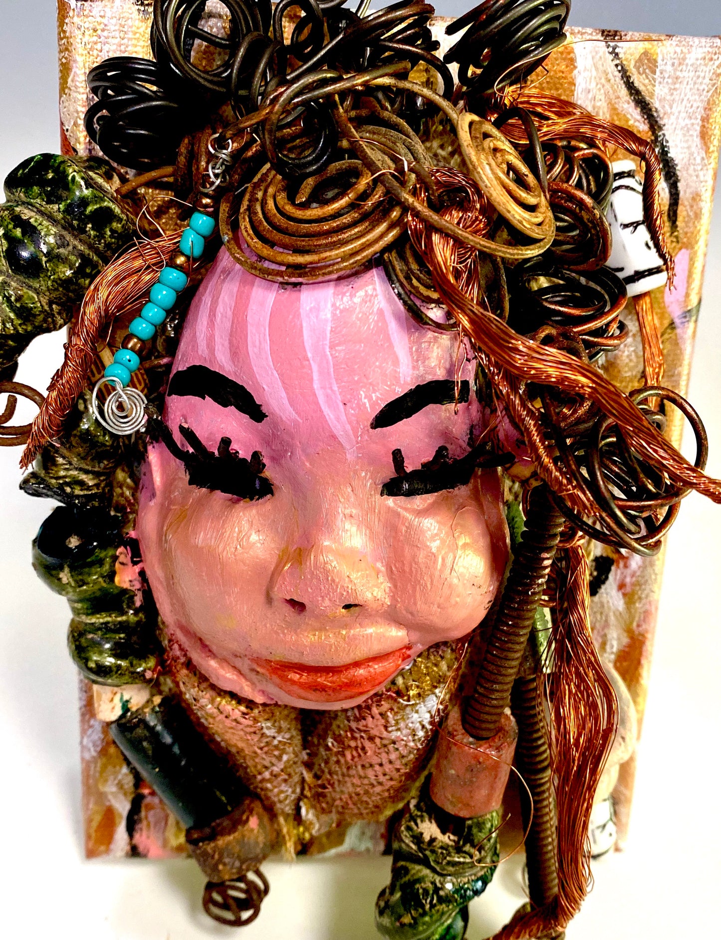 Peggy has a pink and white complexion with ruby red lips! She is mounted on a  5” x 7” and weighs 1.2 lbs. Peggy  has an awesome blue tribal beaded hair dress. She has over 30 feet of coiled 16 gauge wire and copper strands of hair.