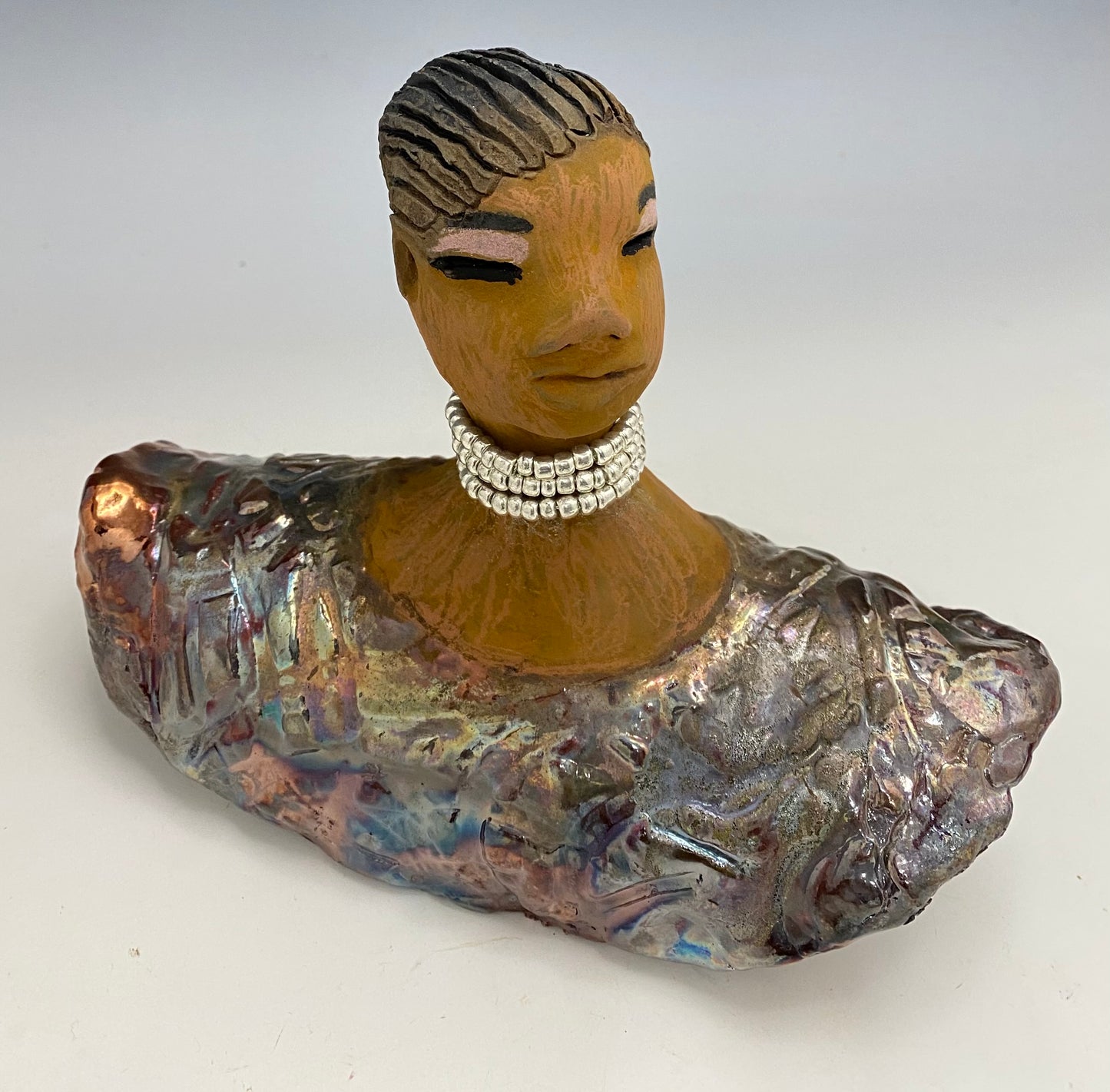 Belinda looks up with joy and anticipation! Belinda stands 6" x 8" x 4" and weighs 1.40 lbs. She has a beautiful textured copper robe trim. Belinda has braided clay hair. She has a honey brown complexion and soft light brown lips. Belinda will make for great conversation in your home.