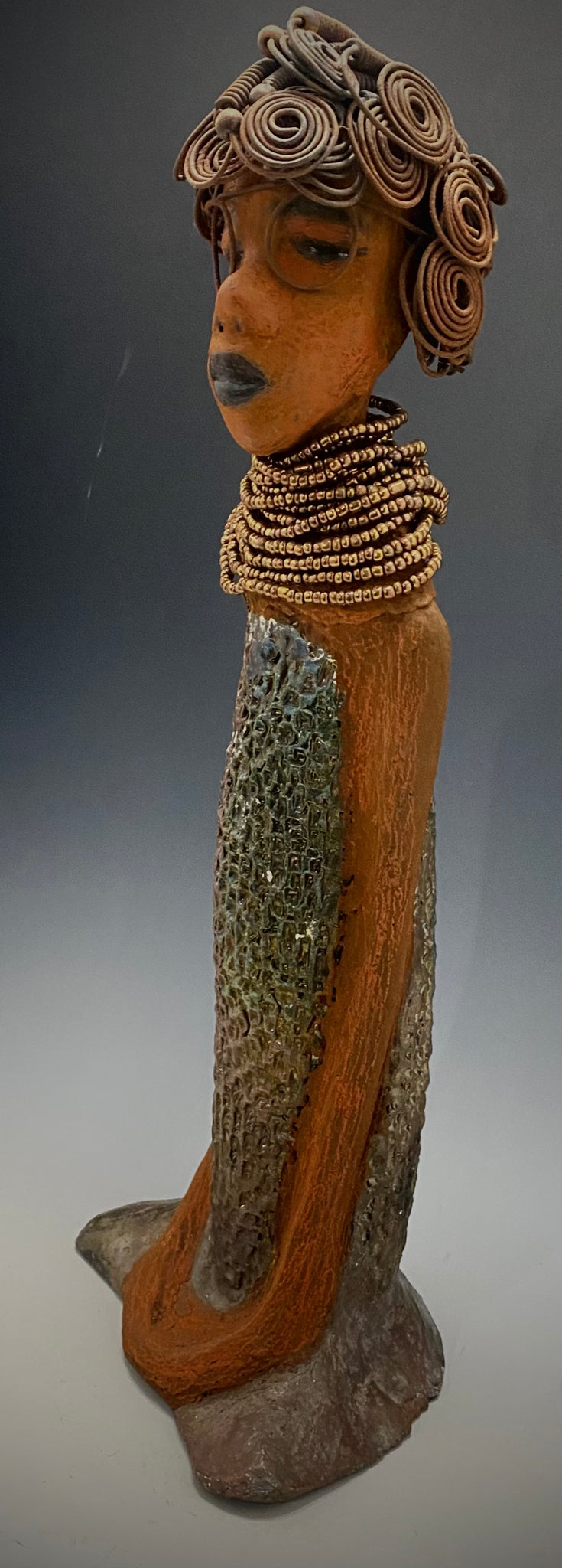 Meet Ernestine! Ernestine stands 18' x 6" x 5" and weighs 5.03 lbs. Ernestine has a lovely honey brown complexion. She has a shimmering copper dress with a huge seed bead necklace. Ernestine is a tall girl with long loving arms. It took several hours to style Ernestine's 16 gauge wire hair! With eyeglasses ,she looks as if she's dreaming or in disbelief. Ernestine is indeed a sophisticated looking lady!   Give Ernestine a new place to stay in your home!