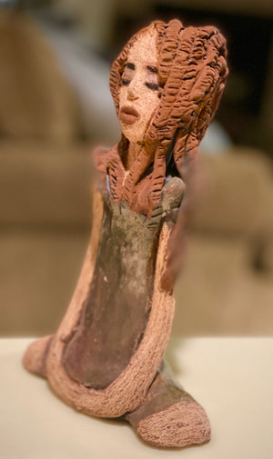 Amani stands 8" x 5" x 2.5" and weighs 1.03 lbs. She has a lovely beige brown complexion with long etched braided clay hair.   Amani long loving arms rest beside her copper green dress. Amani is a sophisticated lady that will grace your home.