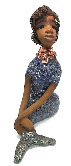      Shelia stands 12" x 10" x 4" and weighs 3.13 lbs.     Shelia has a two tone honey brown complexion.     She has over 15 feet of spiral wire hair which took over two hours to style.     Shelia wears a textured sky blue swimsuit     Her layered spiral copper necklace hangs above her long loving arm.     Shelia is such a ladylike Mermaid. She sits tall and proud. Compare her to Harmony the mermaid.     Give Shelia or Harmony a special place to sit in your home!