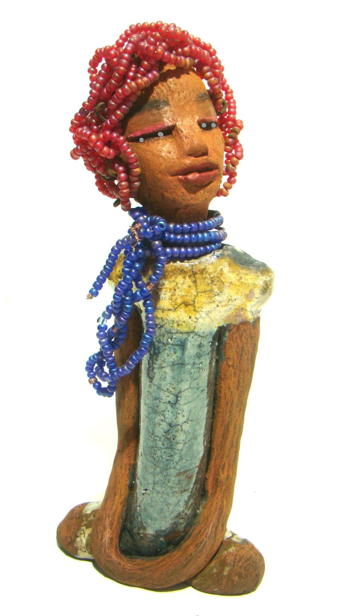 Tiffany stands 10" x 4.5" x 2" and weighs 1.05 lbs. She has a lovely honey tan complexion with purple beaded hair. Tiffany dress is glazed with blue and gold crackle. She wears a blue beaded necklace scarf.
